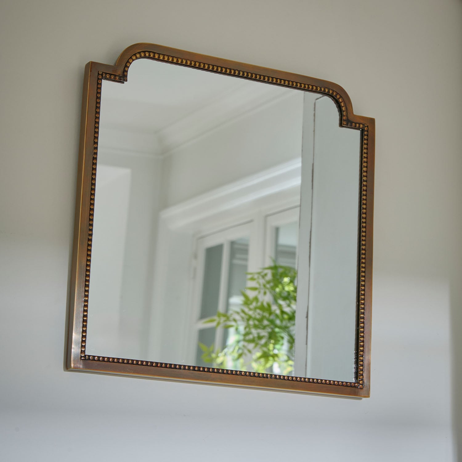 Espejo de pared con marco de latón decorativo, ideal para decoración de interiores