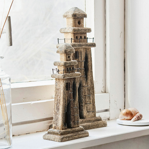 Dos faros decorativos de madera en color natural sobre el alféizar, adorno para interiores