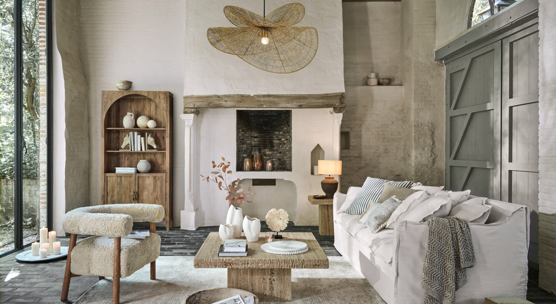 Salón acogedor con sofá blanco, sillón beige y mesa de centro de madera en tonos naturales
