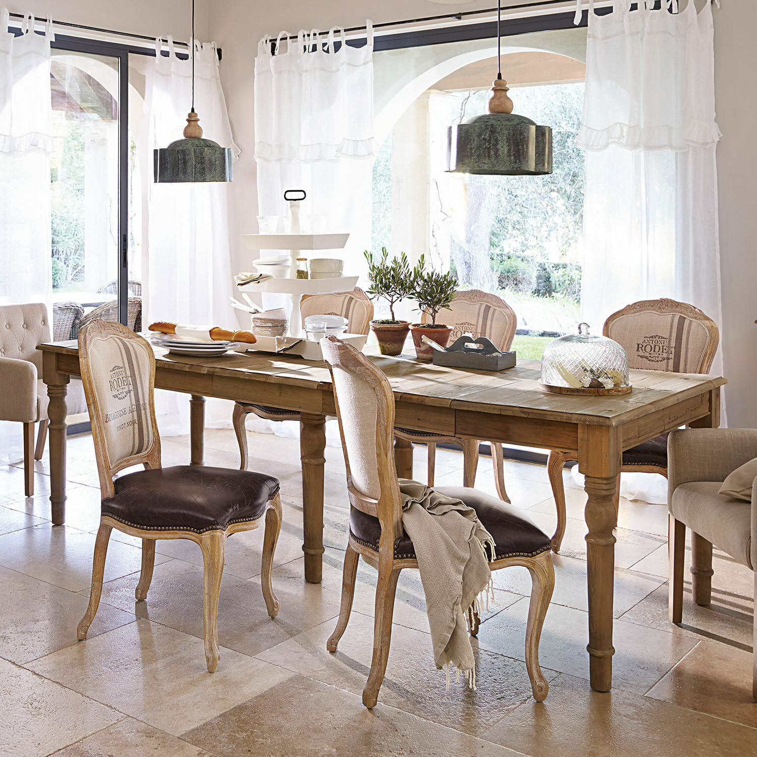 Mesa Bergenfield Comedor con mesa de madera y sillas vintage con tapicería de cuero marrón en ambiente luminoso
