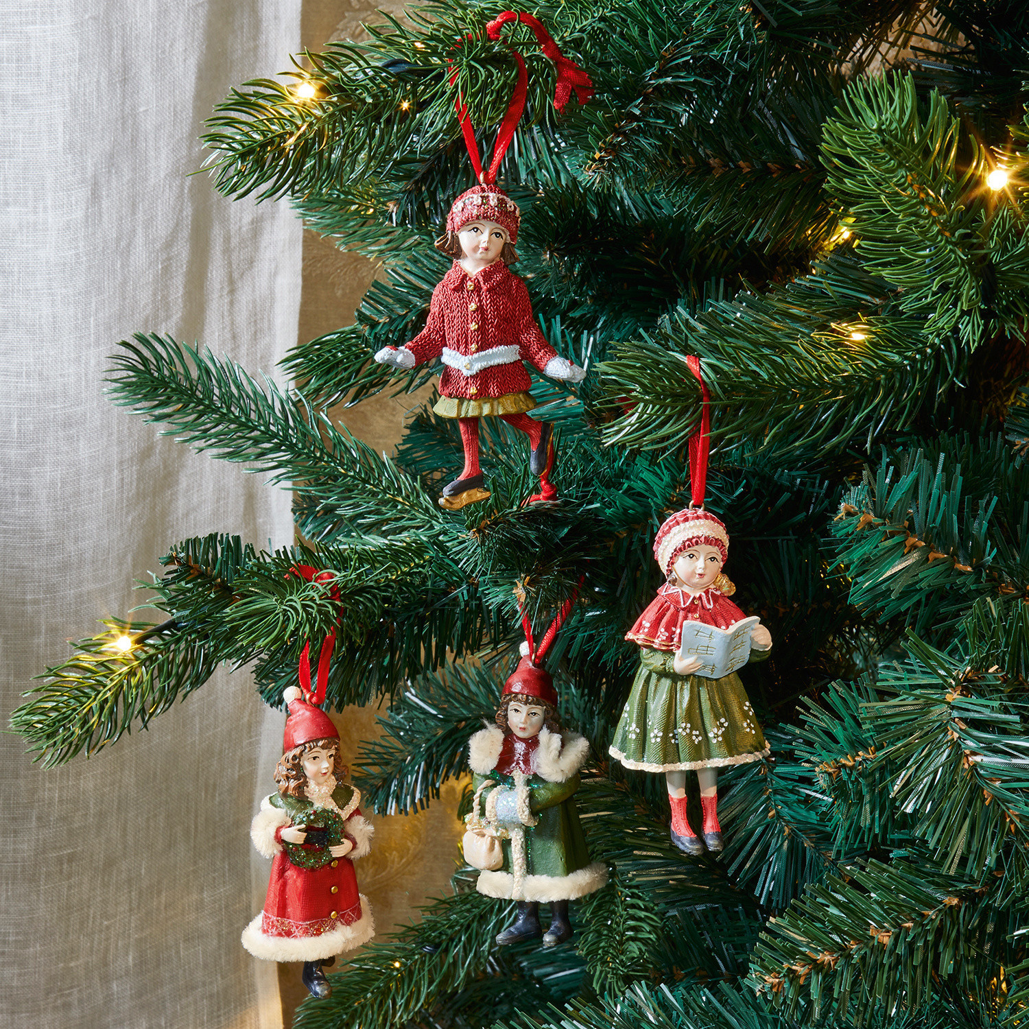Set de 4 colgantes Nostalgic Conjunto de cuatro adornos navideños con figuras de niños con ropa de invierno roja y verde