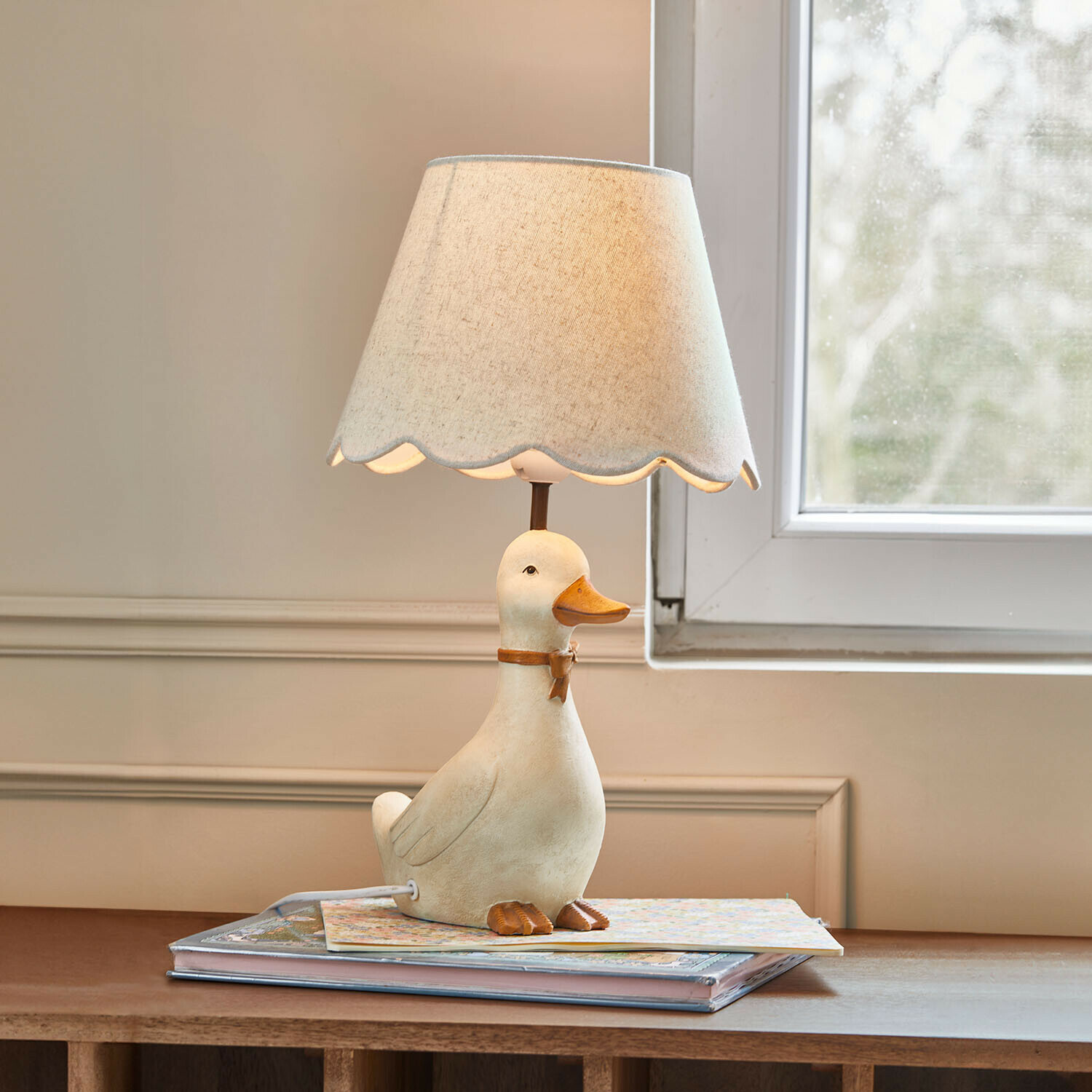 Lámpara de mesa infantil Tillyboo Lámpara de mesa con base de cerámica en forma de pato blanco y pantalla beige con borde ondulado