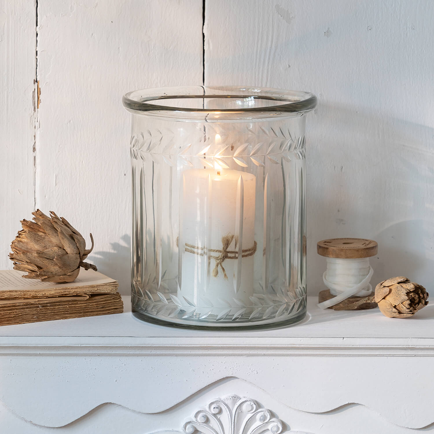 Portavelas de vidrio con vela blanca y diseño de hojas grabado, decoración elegante para interiores