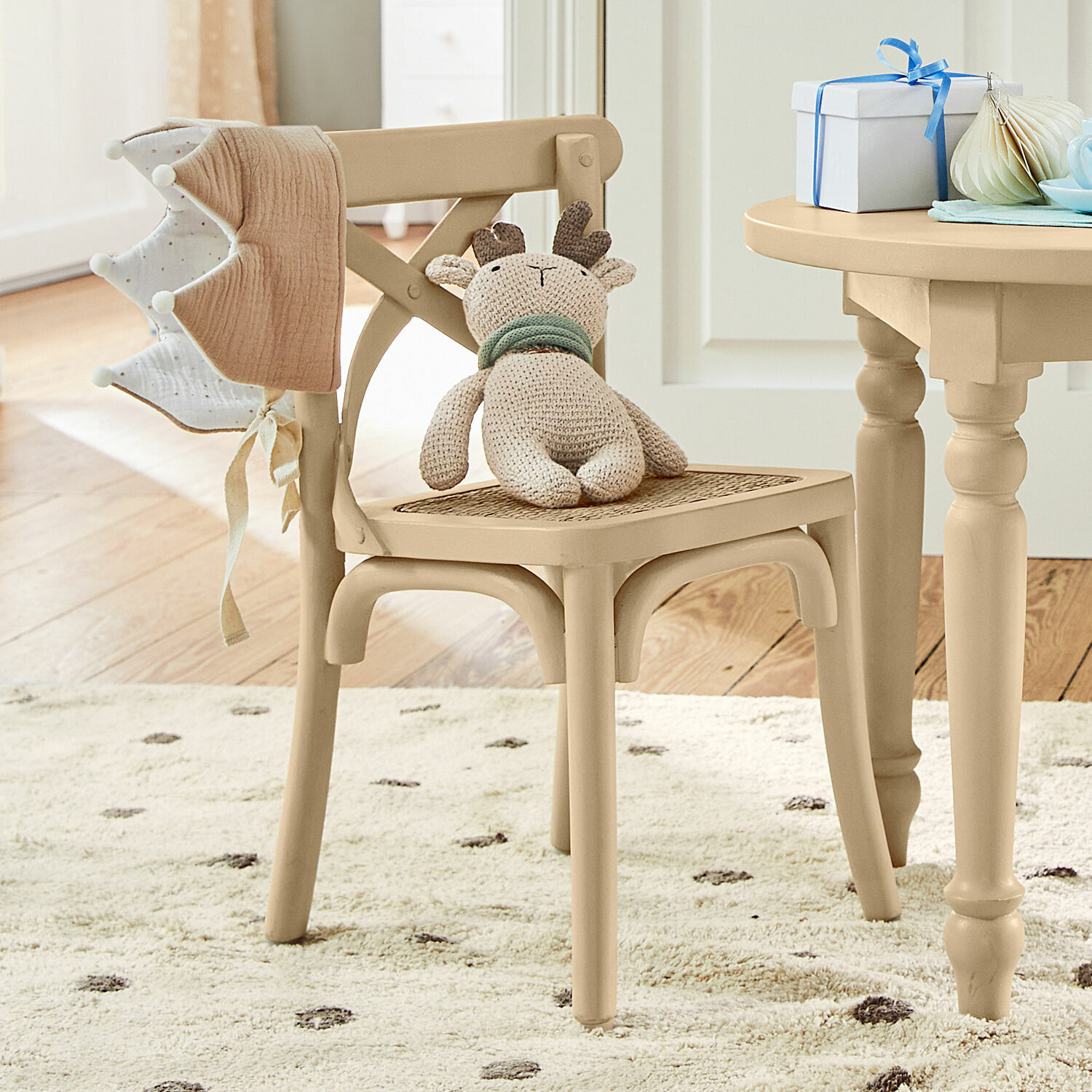 Silla infantil Sourila Silla de madera beige con asiento de mimbre y peluche de reno en habitación infantil