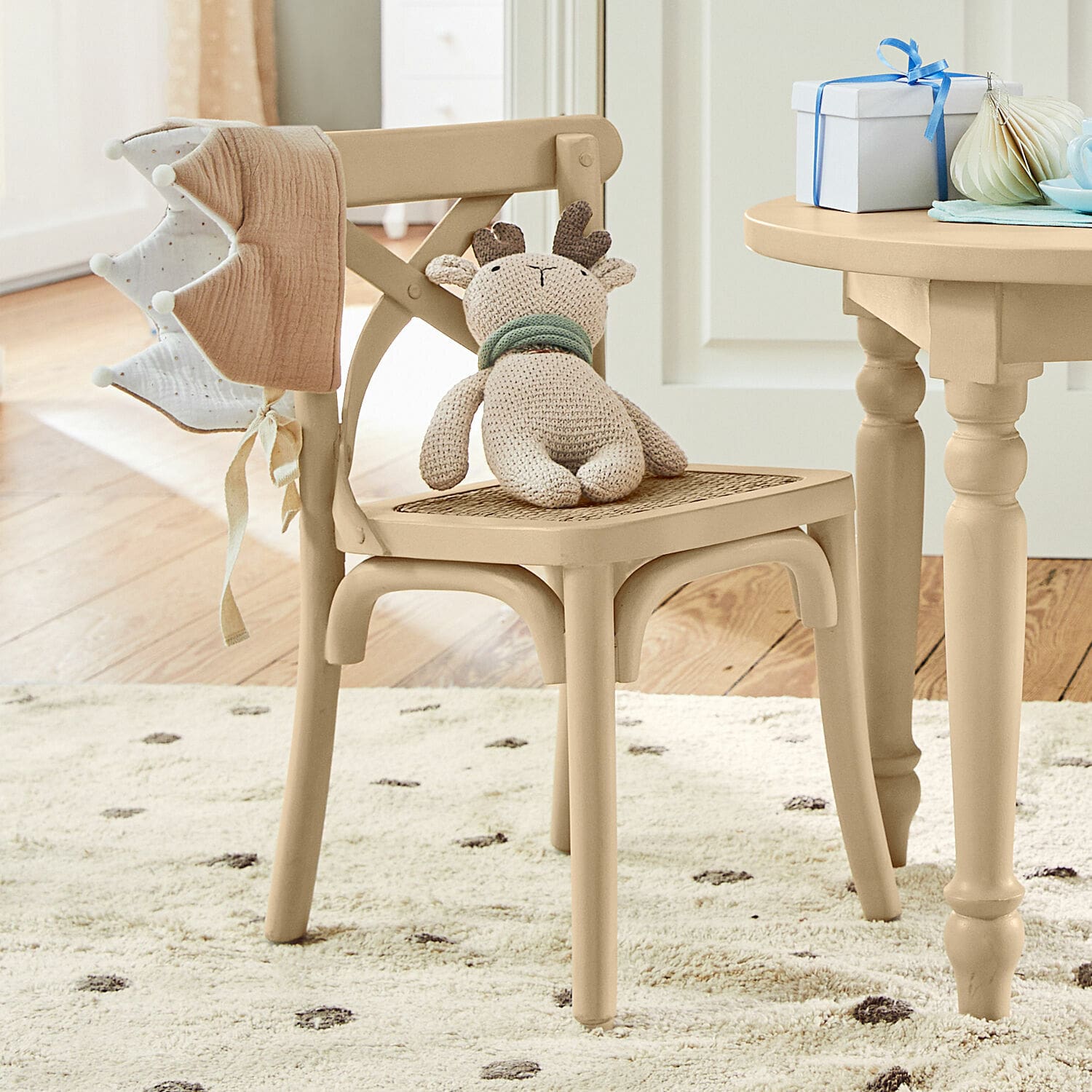 Silla infantil Sourila Silla de madera beige con asiento de mimbre y peluche de reno en habitación infantil