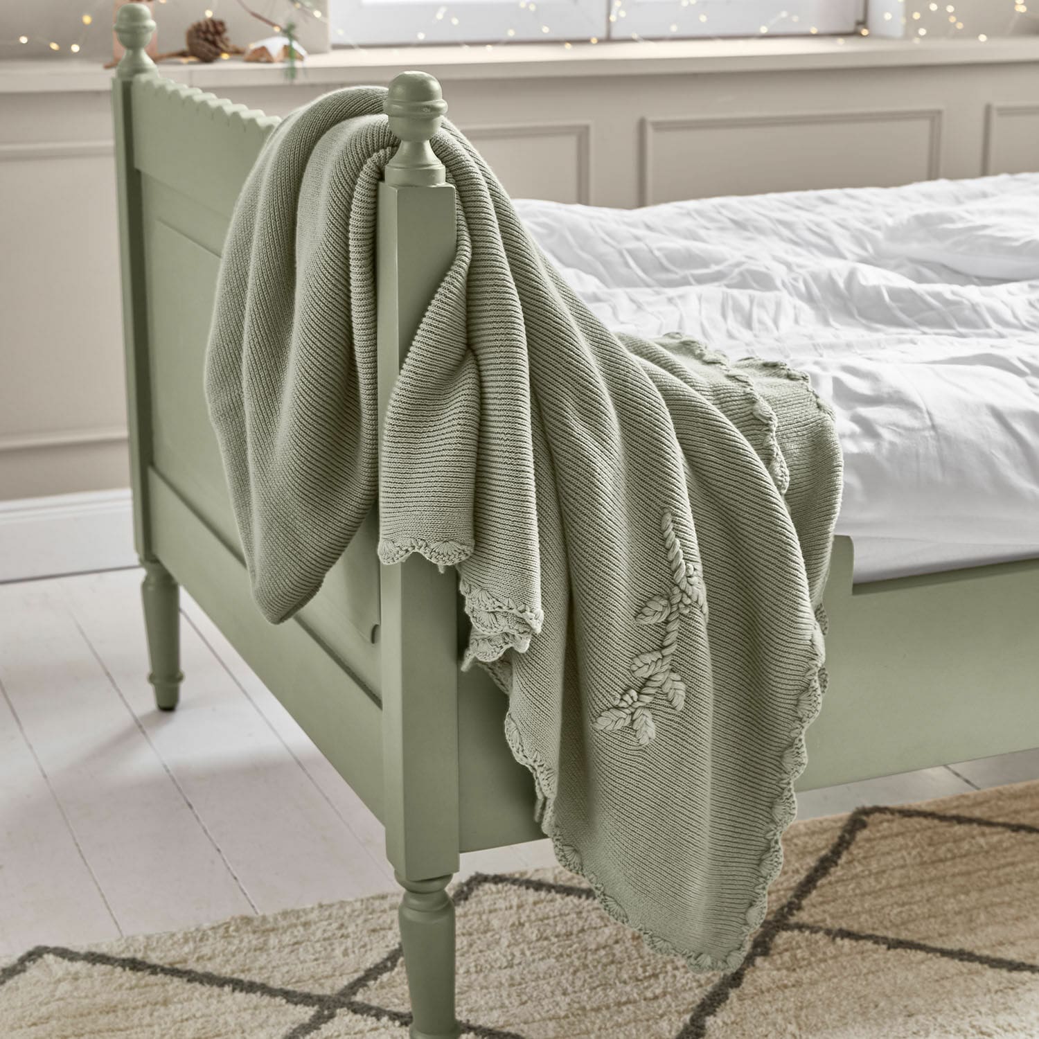 Plaid Aisven Manta verde menta de algodón con bordado sobre cama de madera en dormitorio luminoso, decoración