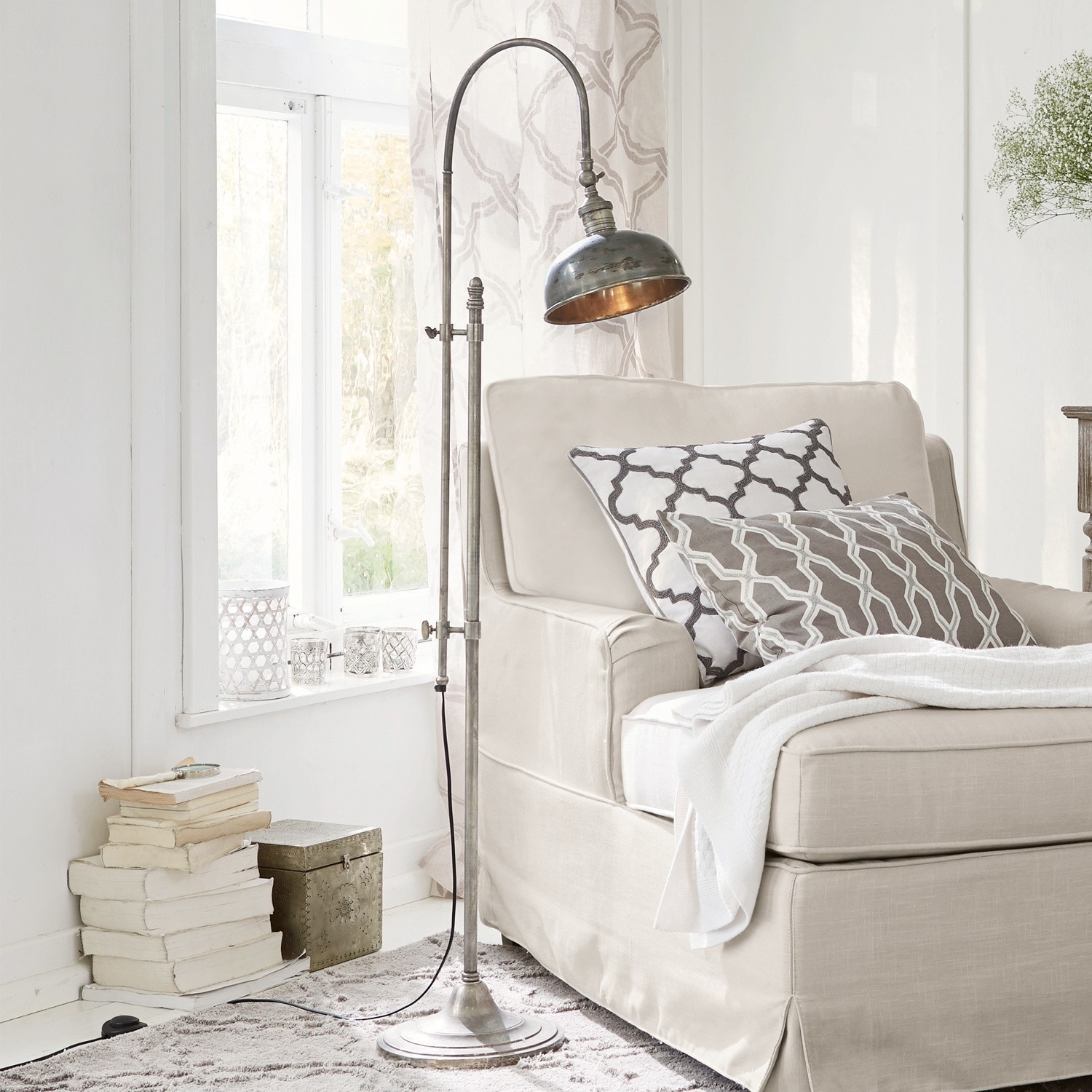 Lámpara de pie Conway Lámpara de pie metálica estilo vintage junto a un sofá beige con cojines y manta en sala luminosa