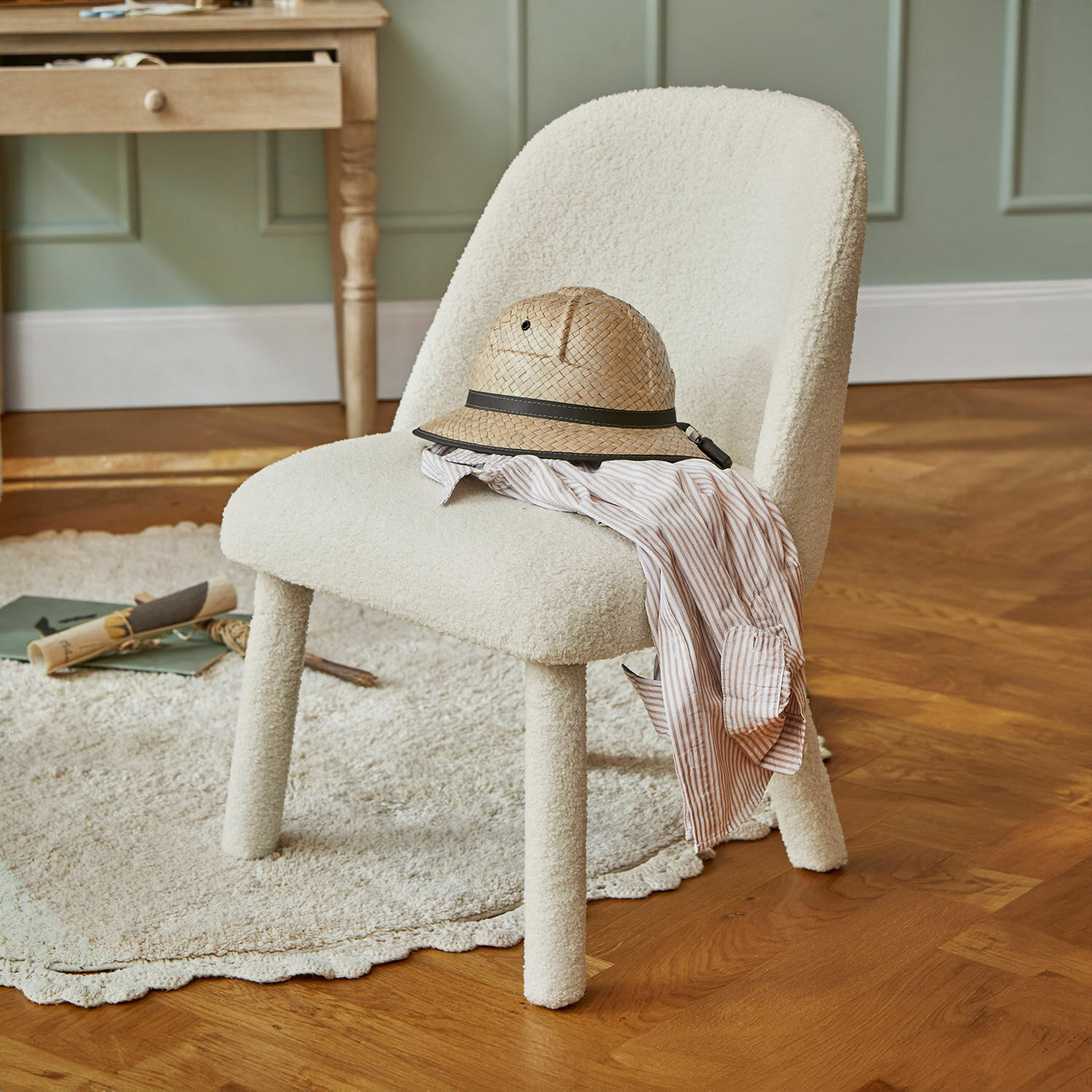 Silla infantil Ivrielle Silla tapizada en tela blanca con sombrero de paja y camisa a rayas sobre suelo de madera