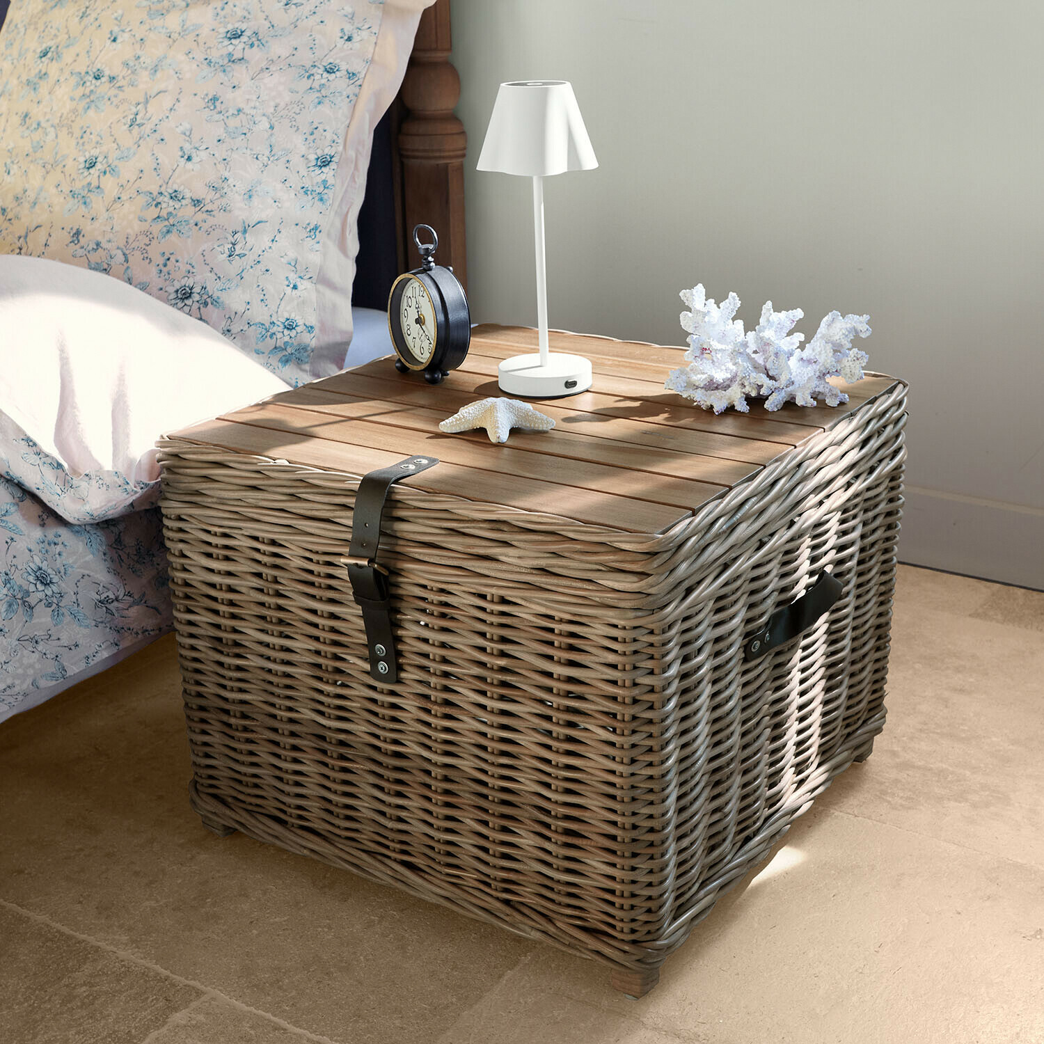 Mesa de noche cuadrada de mimbre gris y madera con lámpara blanca y decoraciones marinas