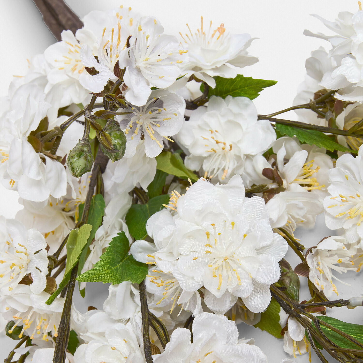 Flores artificiales blancas con hojas verdes en rama para decoración interior