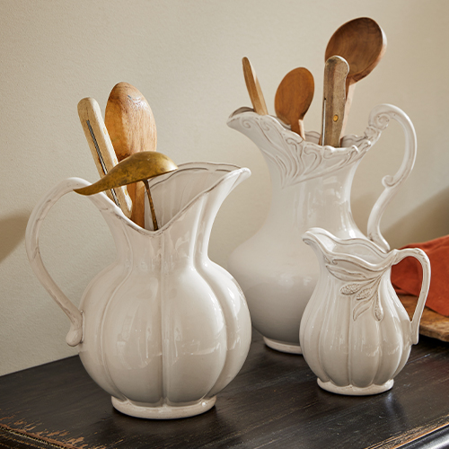 Conjunto de tres jarras de cerámica blanca con diseño decorativo, con cucharas de madera para cocina