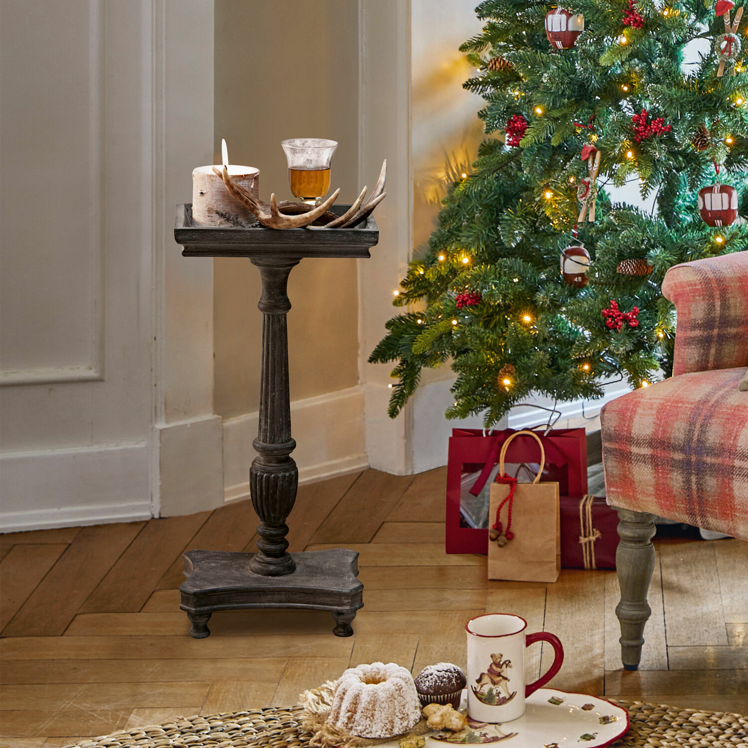 Mesa auxiliar Caren Soporte de madera oscura con vela y decoración de asta junto a árbol de Navidad y regalos