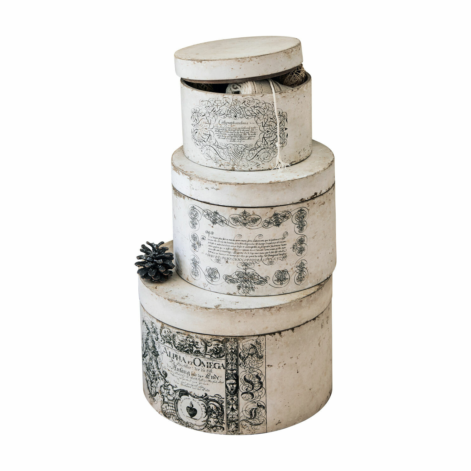 Set de 3 cajas Willma Conjunto de tres cajas redondas de papel color crudo con inscripciones decorativas negras y una piña