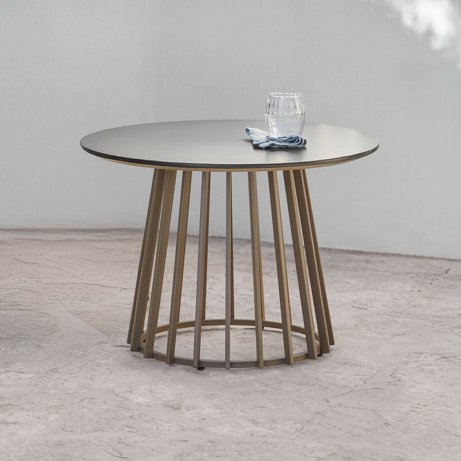 Mesa auxiliar Olianne Mesa redonda con base metálica beige y superficie gris mate, diseño contemporáneo
