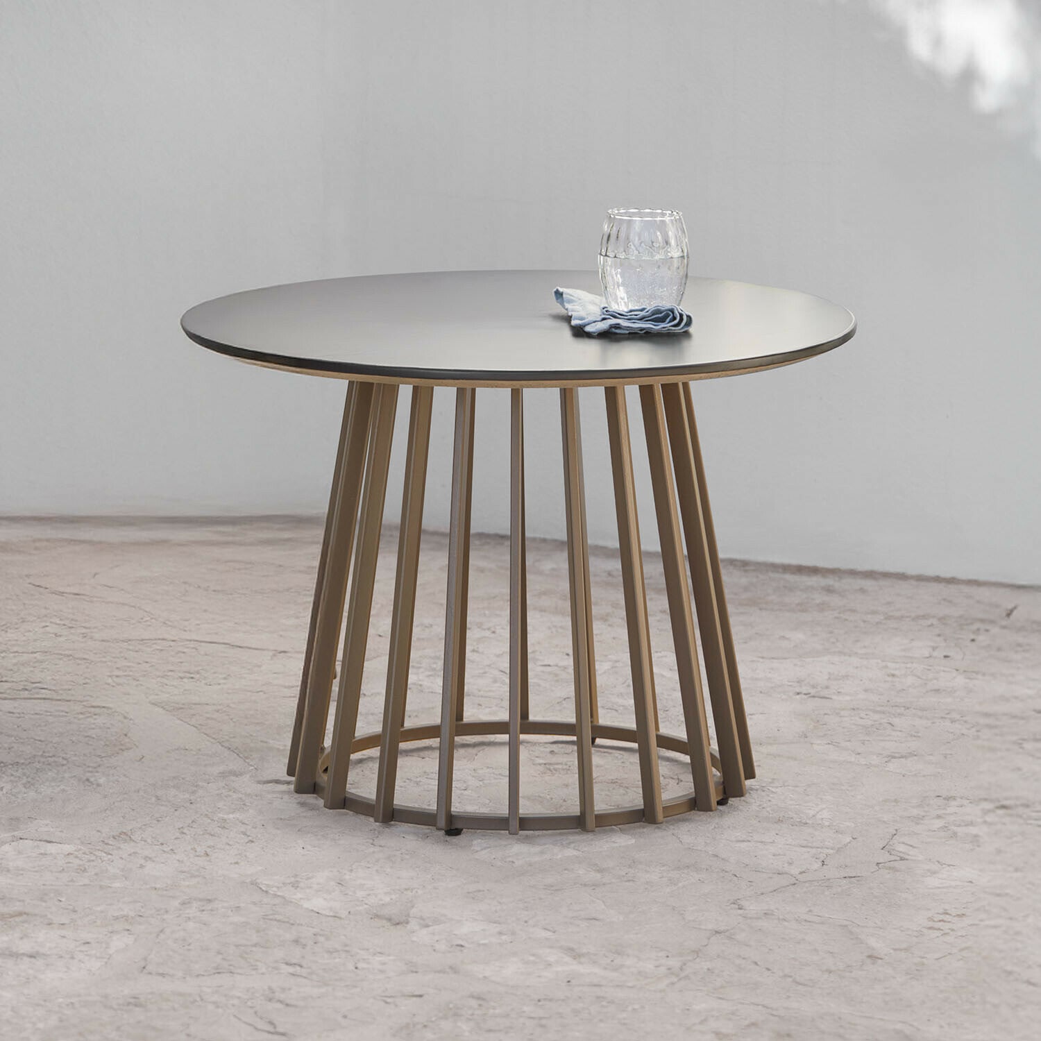 Mesa auxiliar Olianne Mesa redonda con base metálica beige y superficie gris mate, diseño contemporáneo