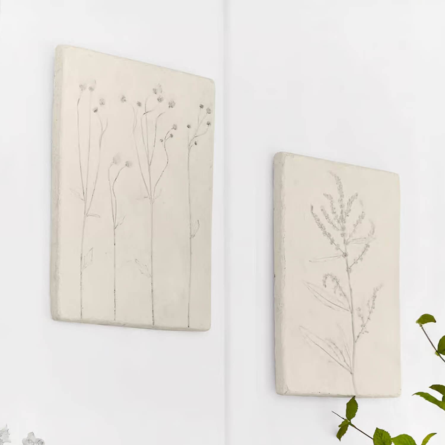 Dos paneles decorativos blancos con motivos vegetales delicados para decoración natural