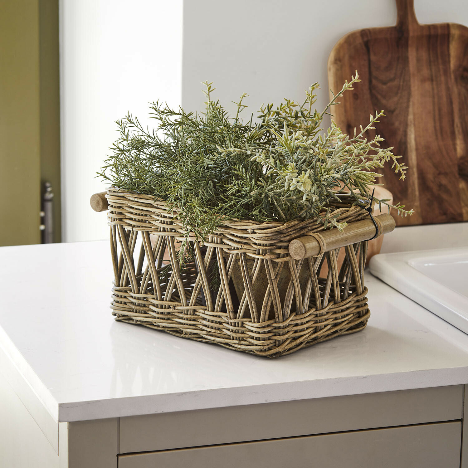 Cesta Kettlewells Cesta rústica de ratán natural con plantas verdes sobre encimera de cocina moderna