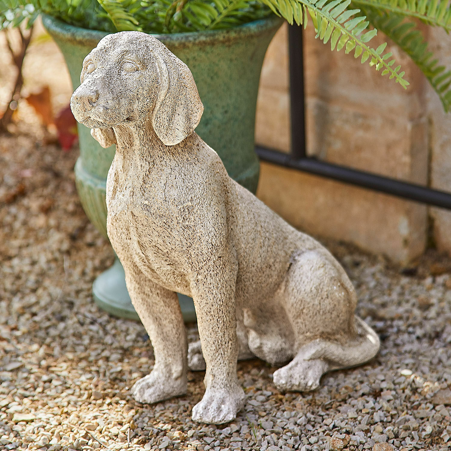 Perro decorativo Albinor Escultura decorativa de perro de piedra beige en jardín sobre grava
