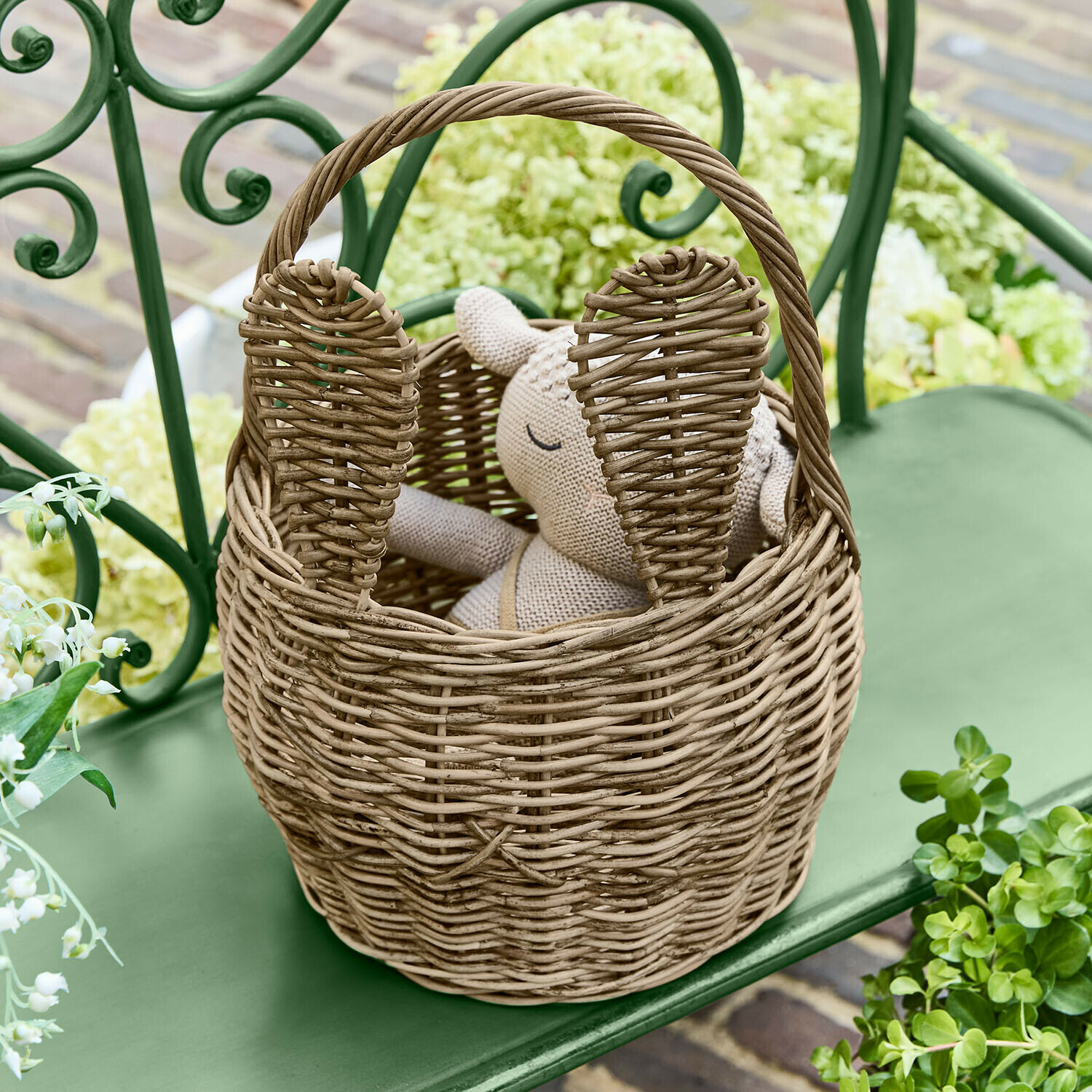 Cesta con forma de conejo Whimsywood Cesta de mimbre natural con forma de conejo y orejas, sobre banco verde en jardín
