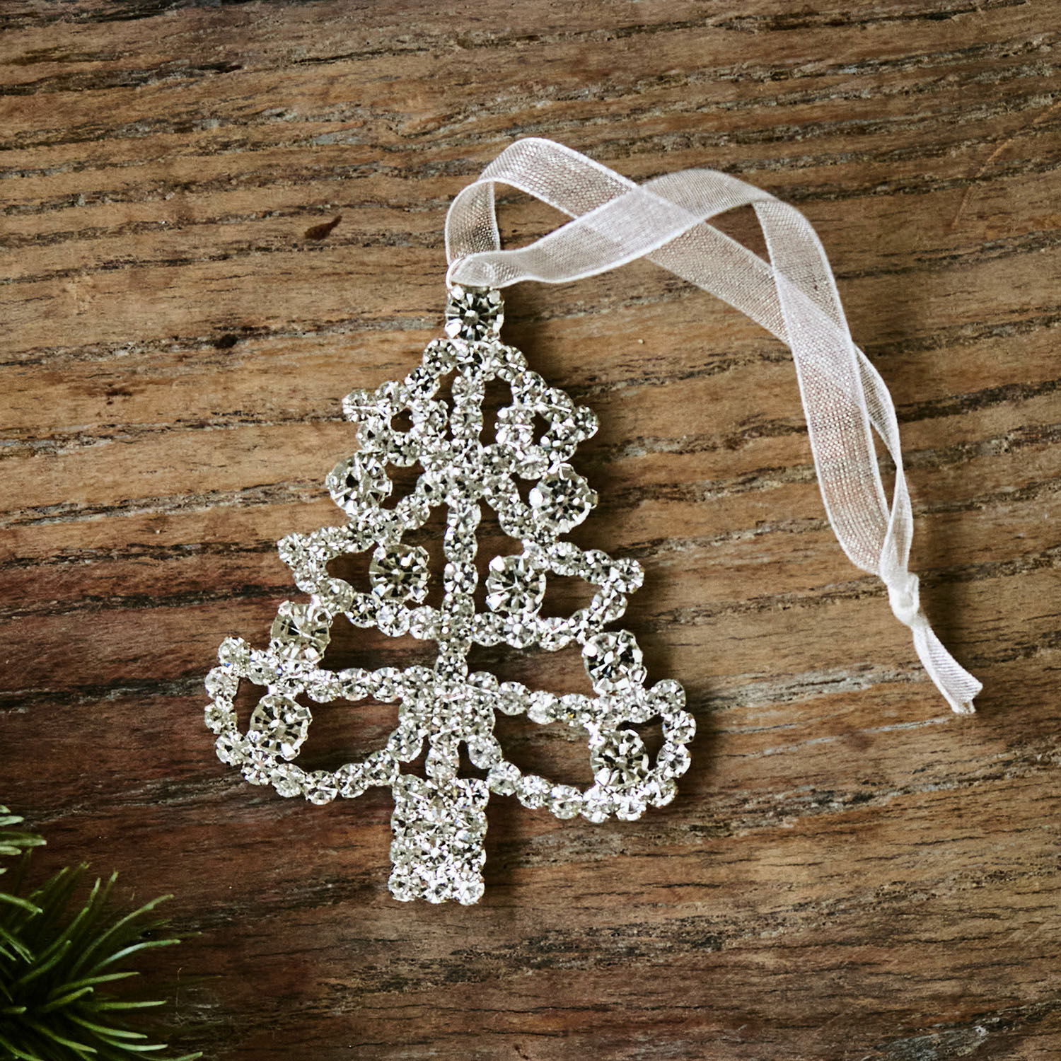 Colgante Orilane Adorno navideño brillante en forma de árbol con cristales y cinta blanca sobre fondo de madera