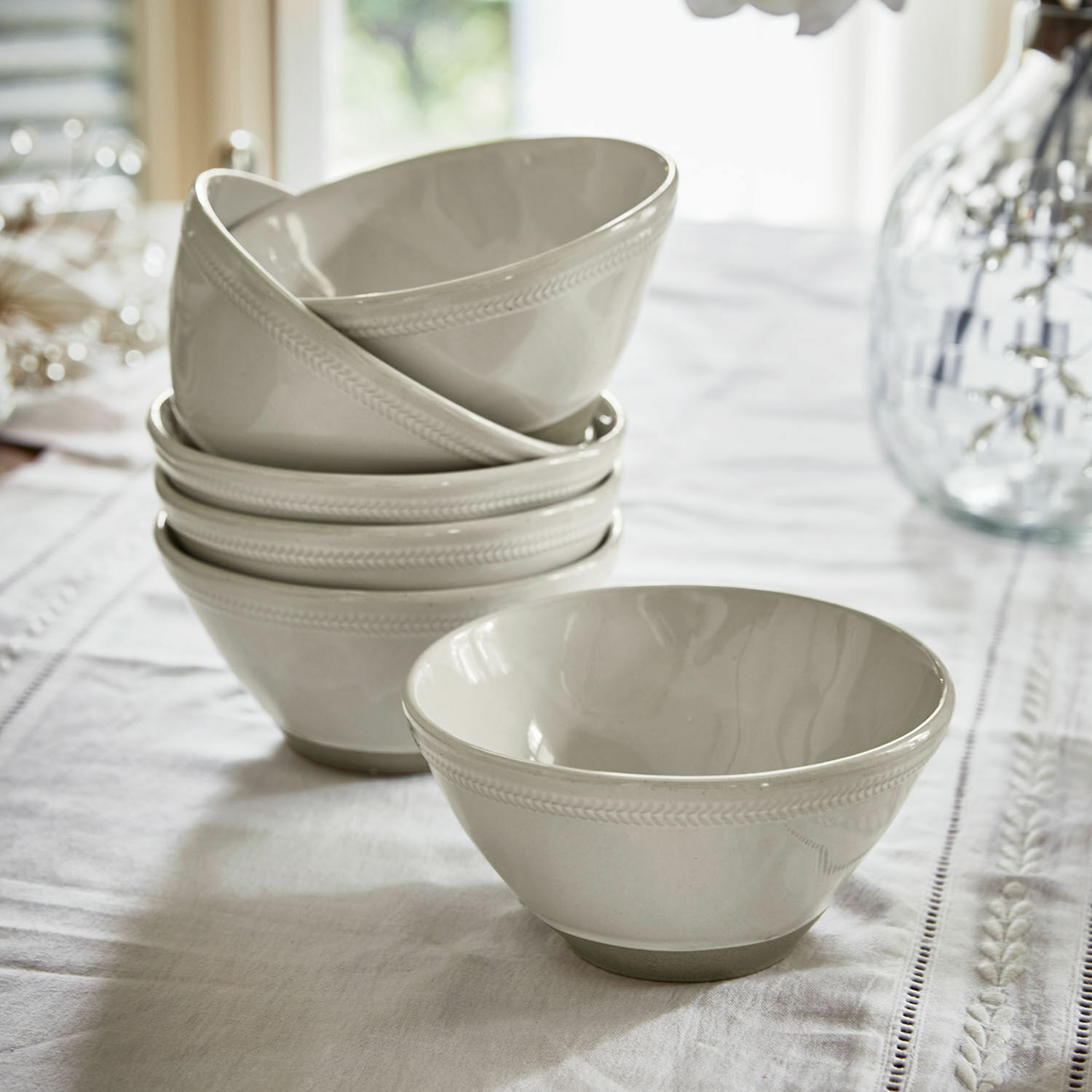 Set de 6 cuencos Norrvik Conjunto de cuencos de cerámica blanca con diseño sutil en el borde sobre mantel blanco