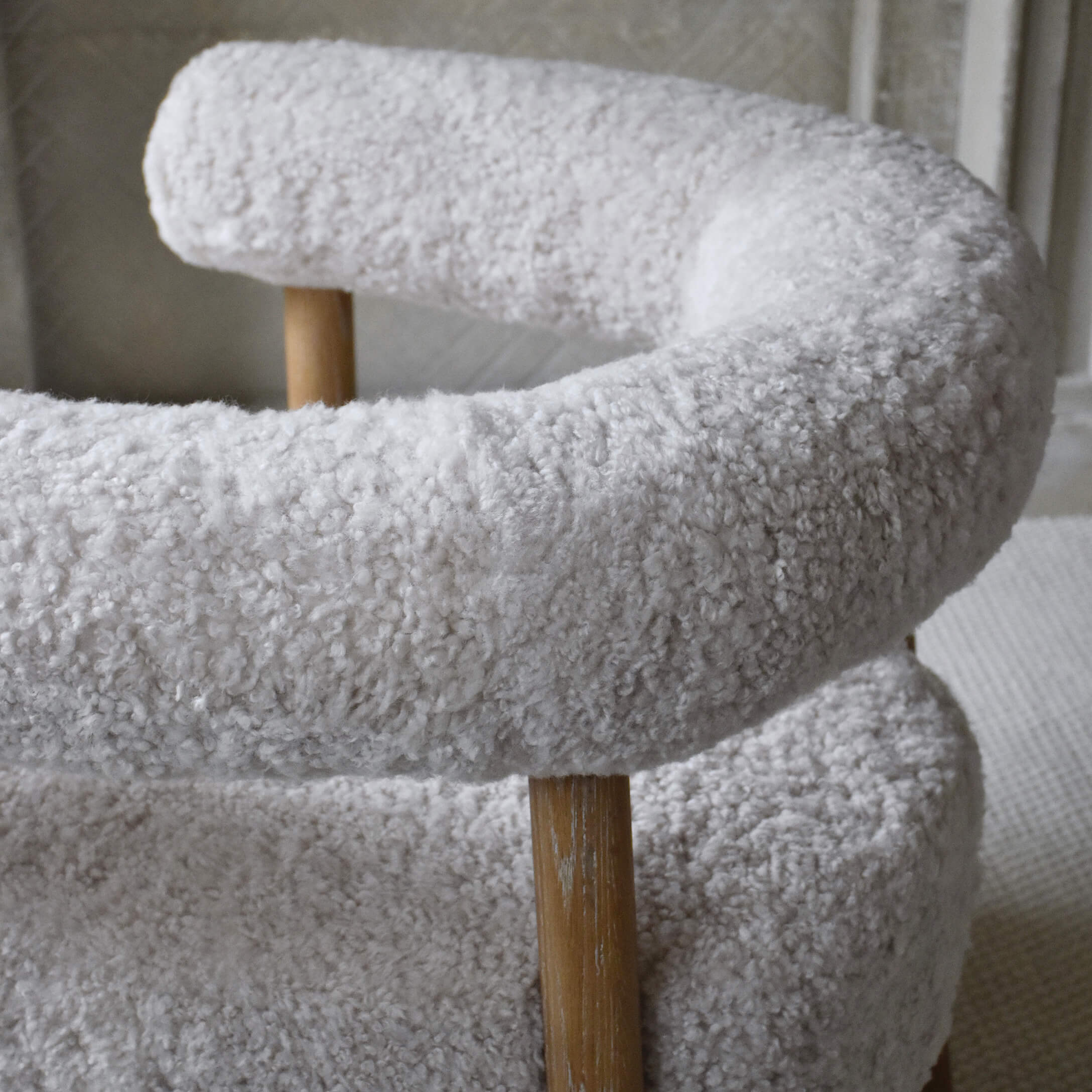 Sillón suave con tapizado de felpa blanca y patas de madera para salón moderno