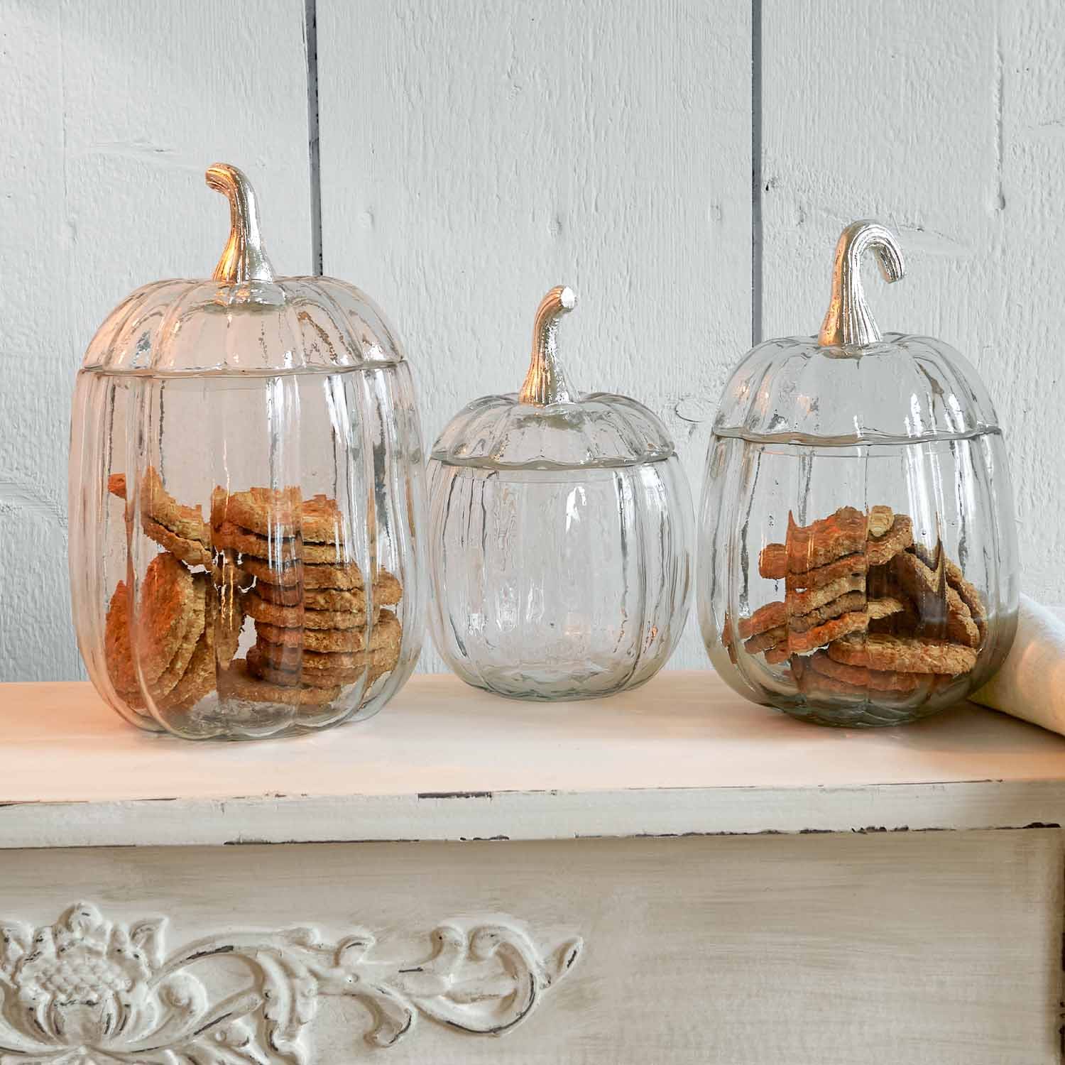 Recipientes de vidrio con forma de calabaza y tapas plateadas, ideales para guardar galletas