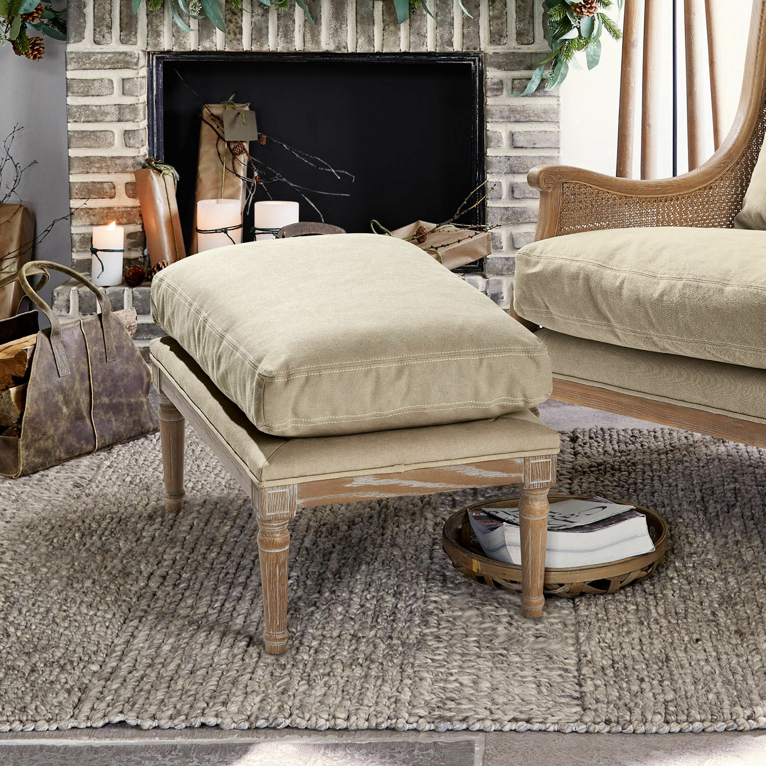 Taburete Greenbrier Reposapiés beige con marco de madera y cojín de tela suave sobre alfombra en sala acogedora
