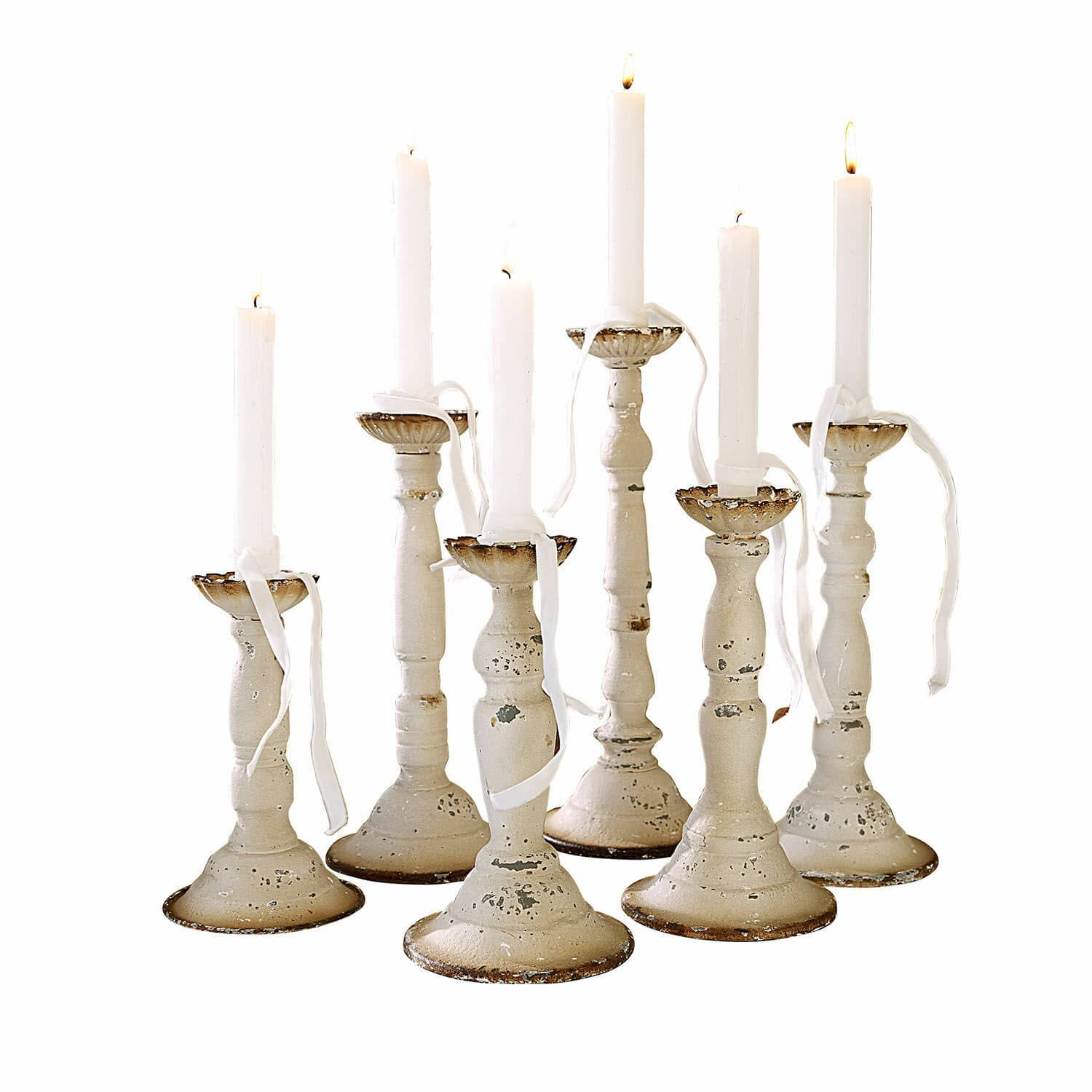 Set de 6 candeleros Rivondelle Conjunto de siete candelabros de metal blanco envejecido con velas blancas encendidas