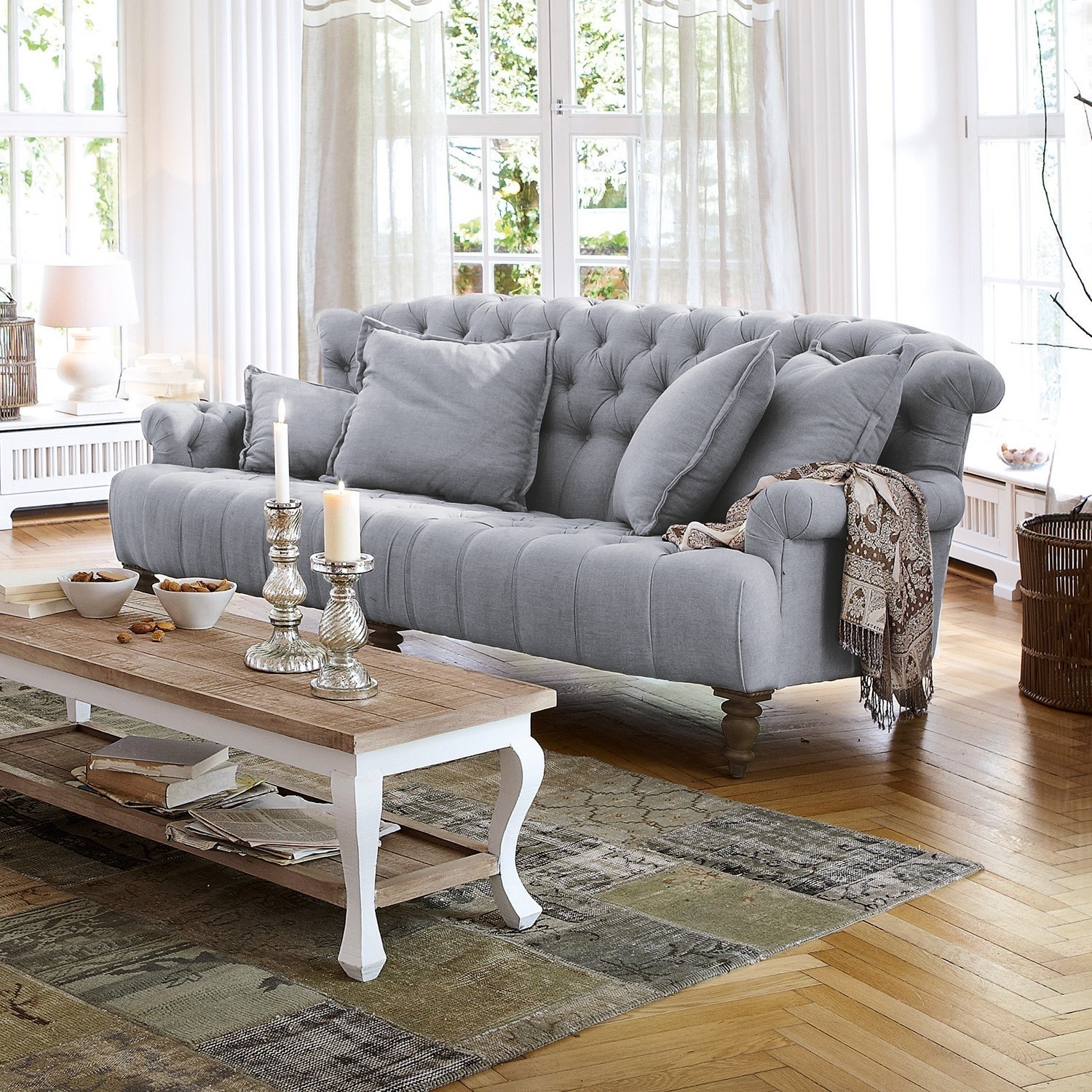 Sofá Springfield Village Sofá tapizado gris con cojines y mesa de centro de madera en sala luminosa