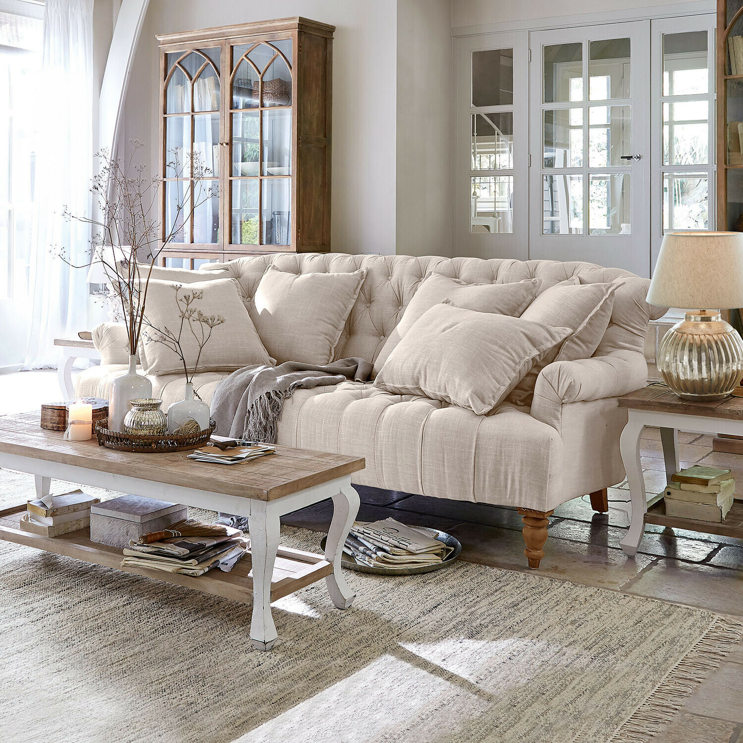 Sofá Springfield Village Sofá tapizado beige con cojines y mesa de centro de madera en sala luminosa