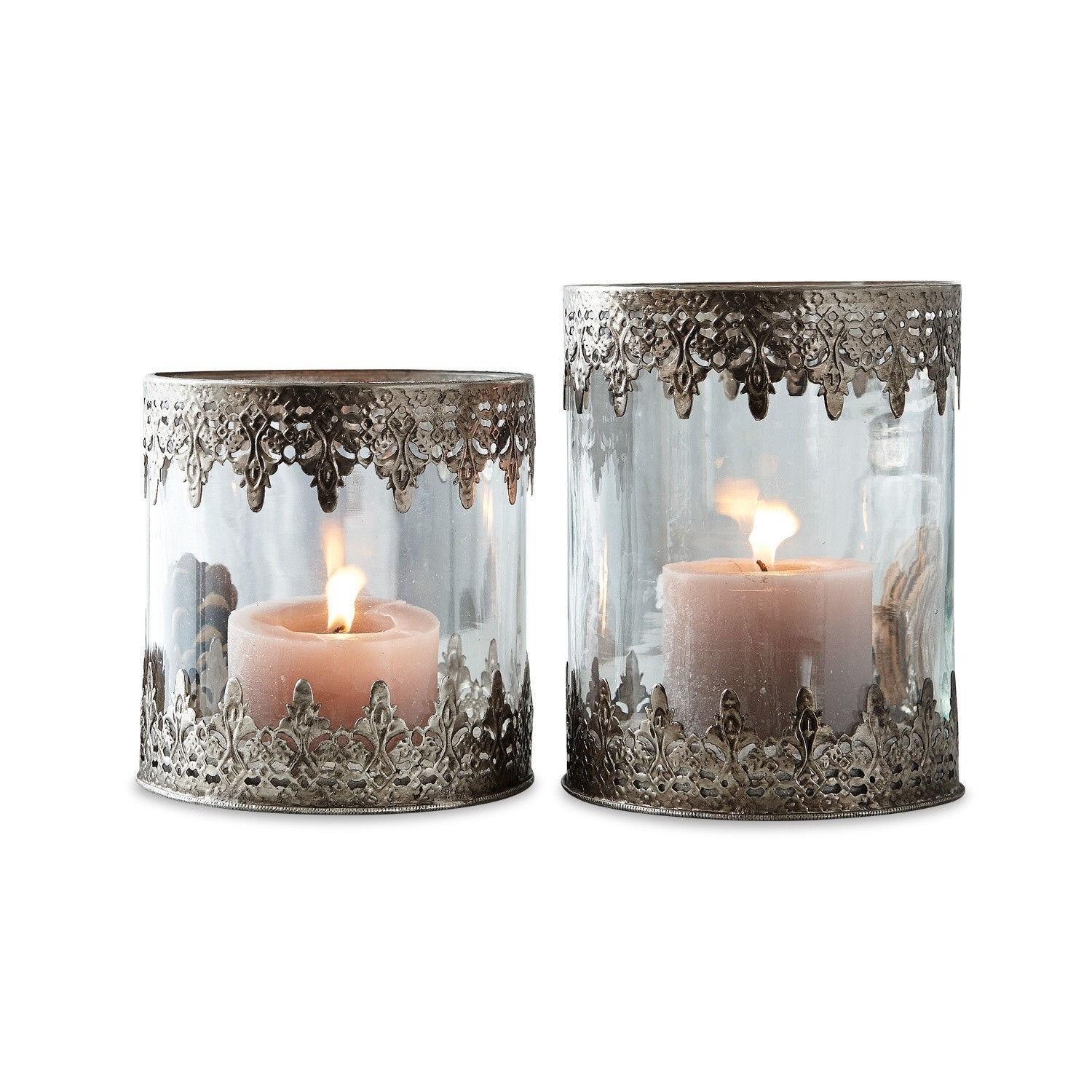 Conjunto de dos portavelas de vidrio con decoración metálica calada plateada y velas encendidas dentro