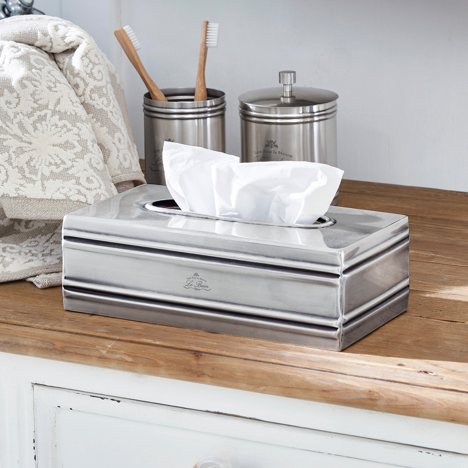 Caja de pañuelos Suzette Dispensador metálico plateado para pañuelos sobre encimera de madera en baño