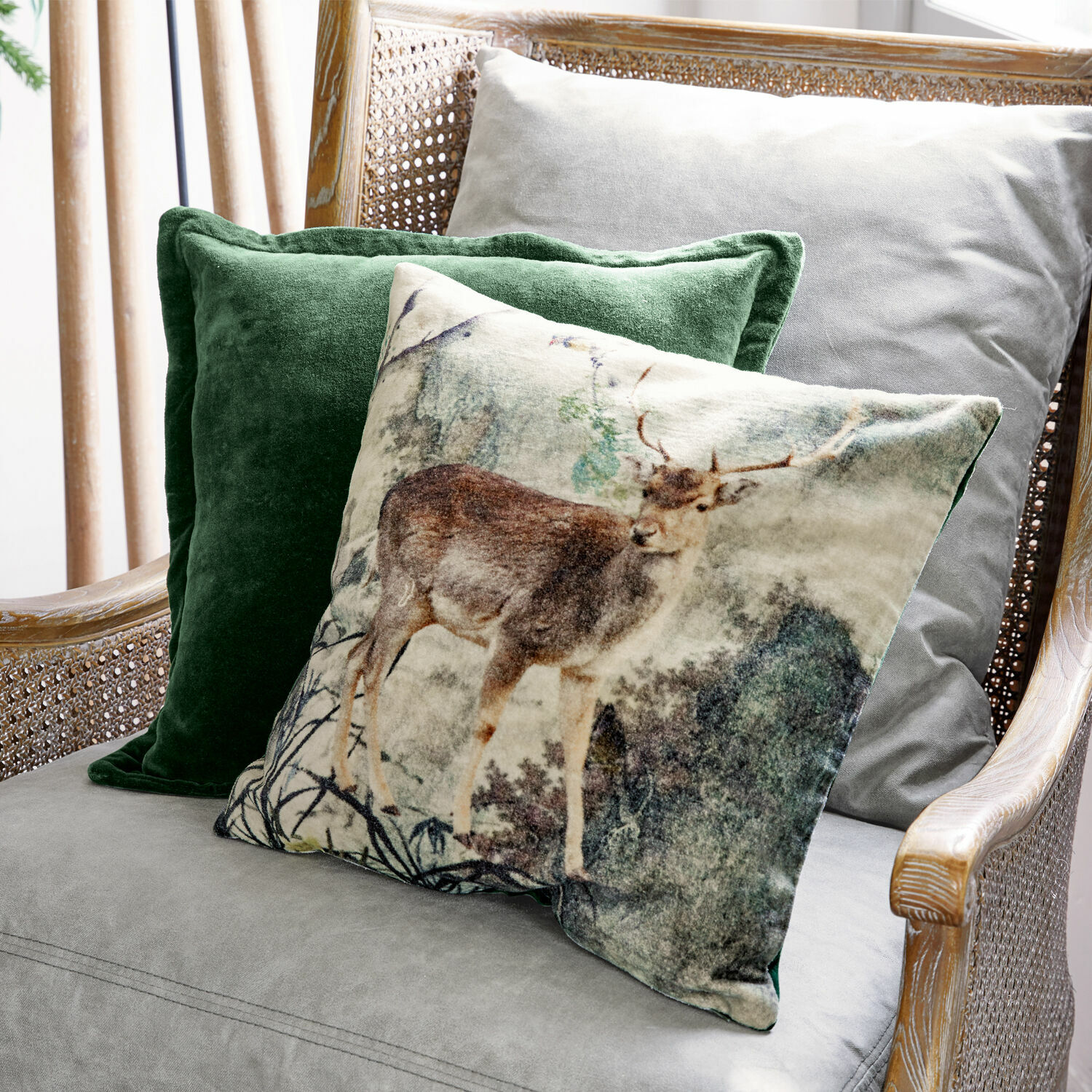 Set de 2 fundas de cojín Anie Conjunto de cojines decorativos con motivo de ciervo y terciopelo verde en sillón gris