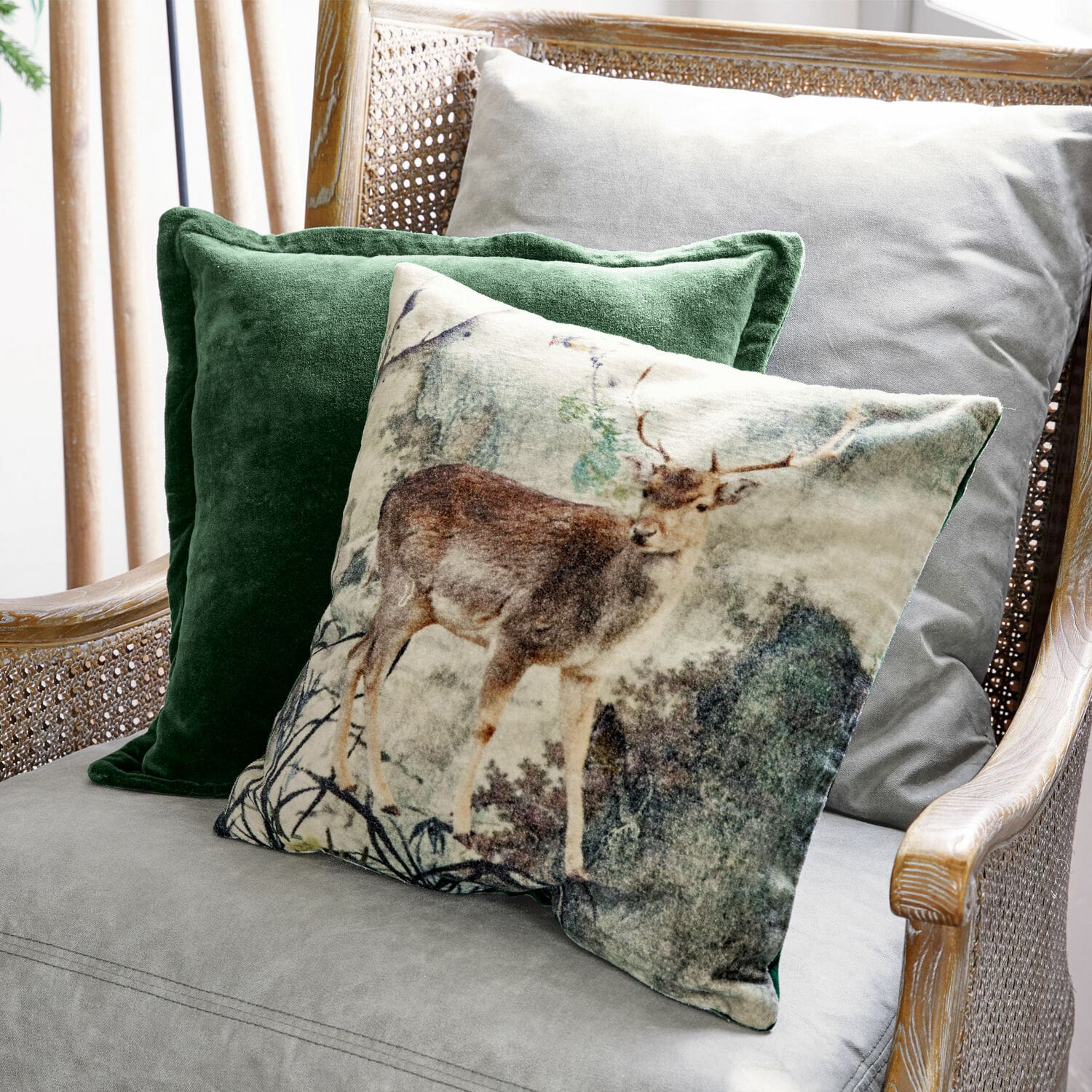 Set de 2 fundas de cojín Anie Conjunto de cojines decorativos con motivo de ciervo y terciopelo verde en sillón gris