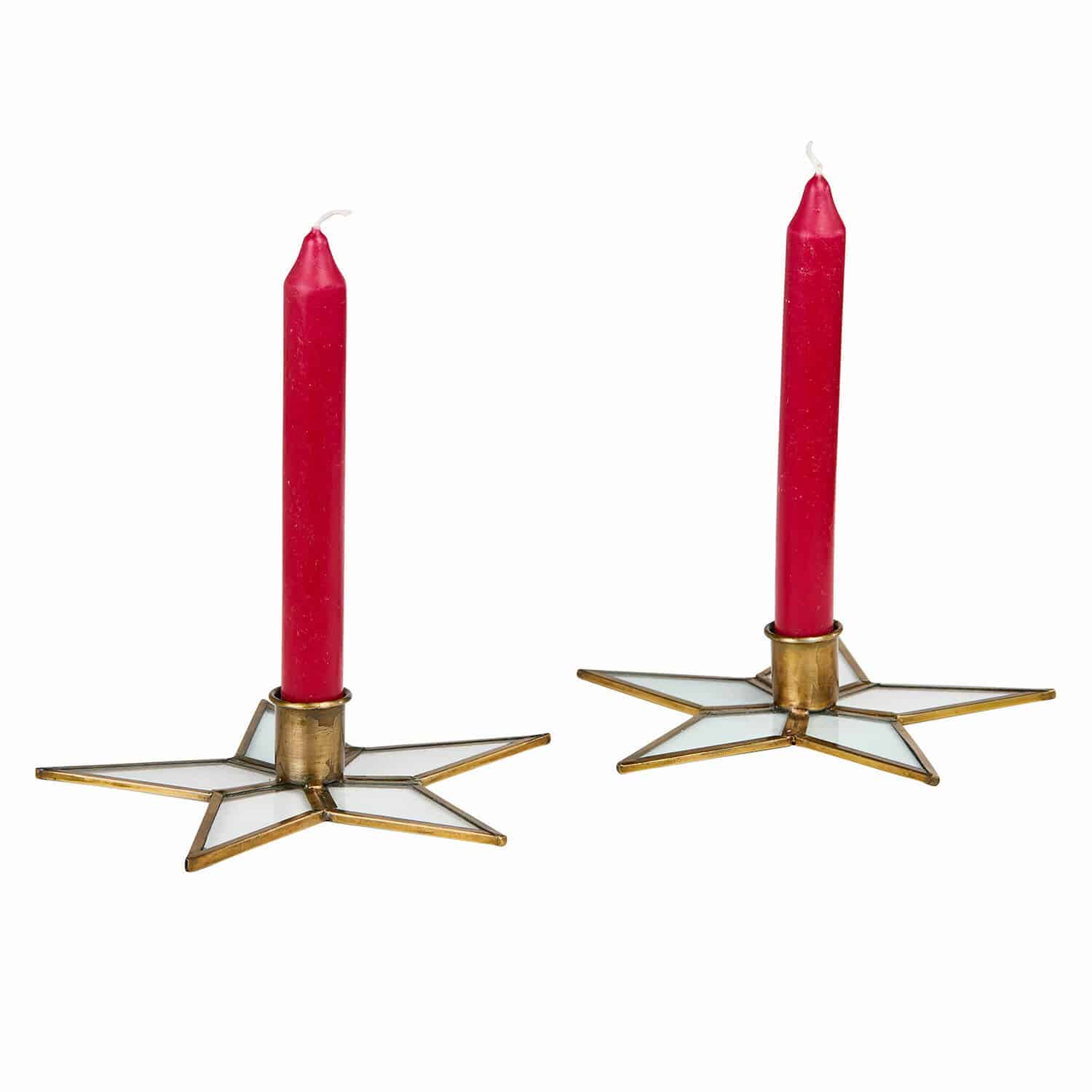 Par de velas rojas en candelabros metálicos en forma de estrella con vidrio blanco sobre fondo blanco