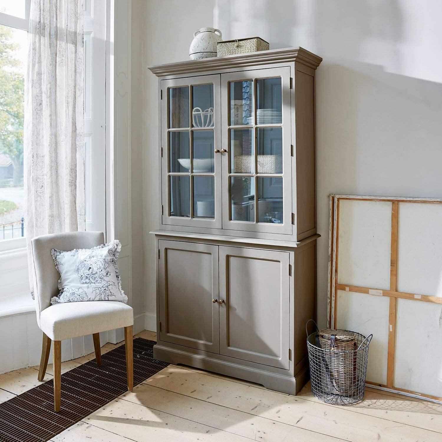 Armario Rosebrook Vitrina de madera gris con puertas de cristal y estantes en sala luminosa