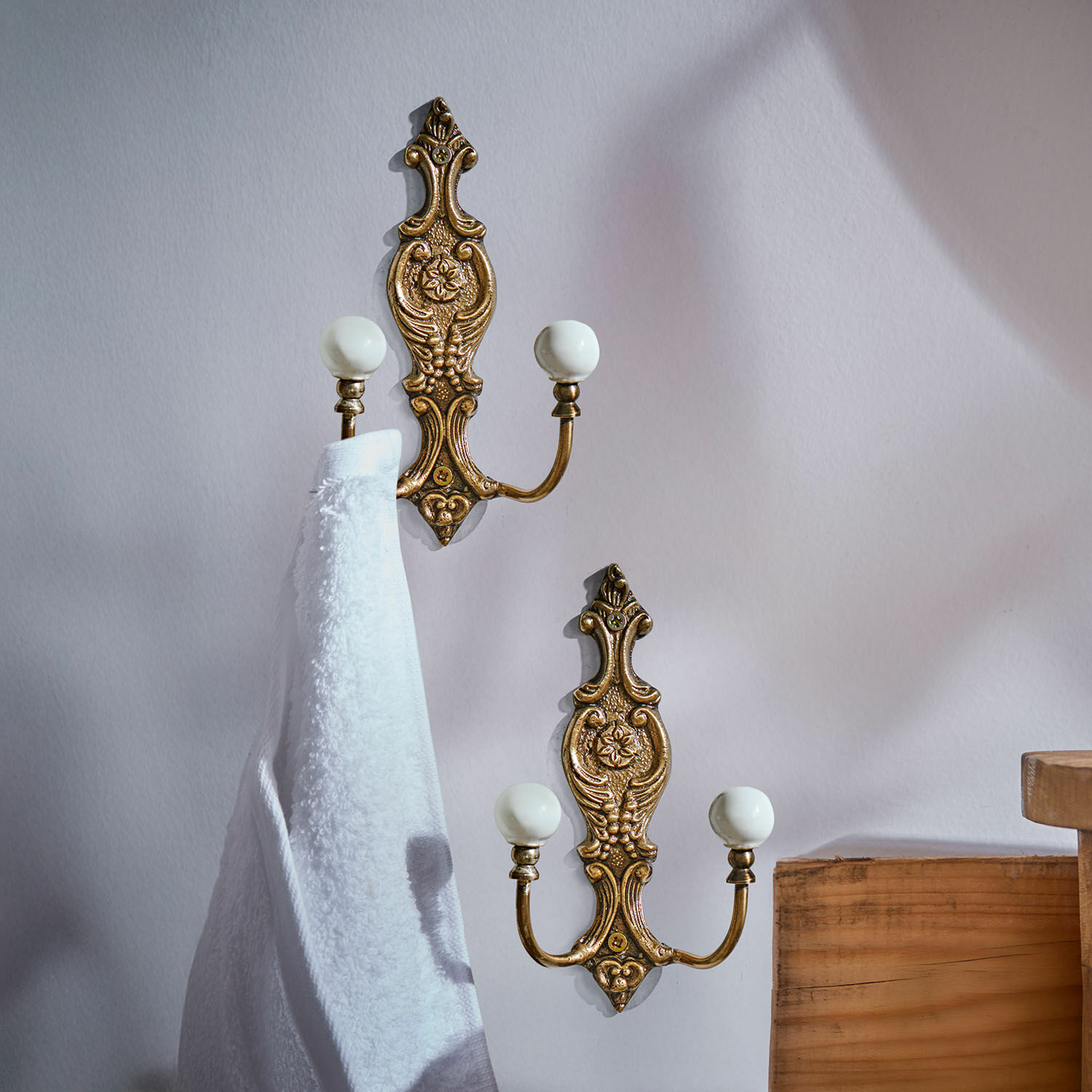 Set de 2 ganchos Nuvéal Conjunto de dos perchas de pared de latón con pomos de cerámica blanca y diseño decorativo