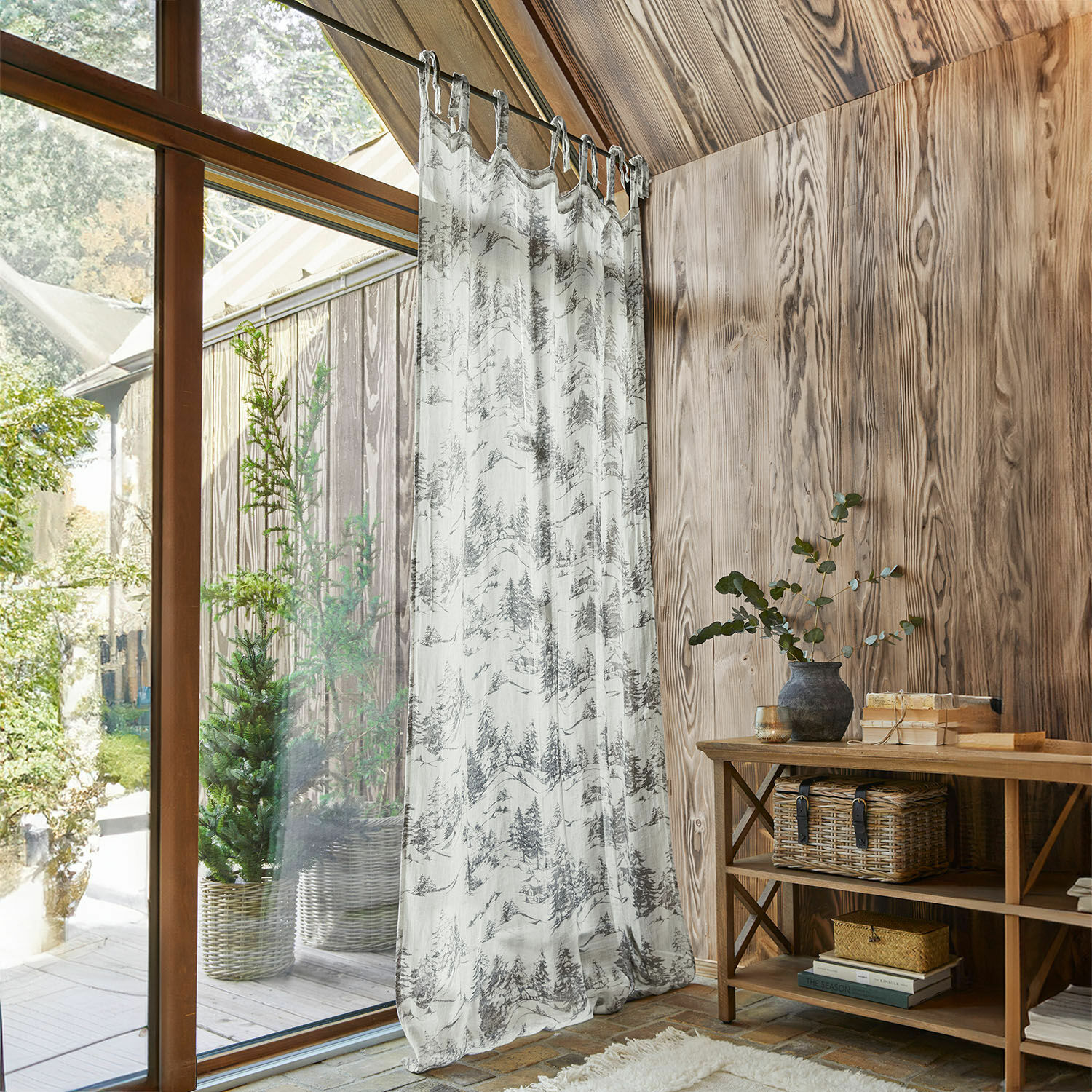 Cortina Héroux Cortina translúcida con estampado de árboles en tonos gris y blanco en interior de madera con luz natural