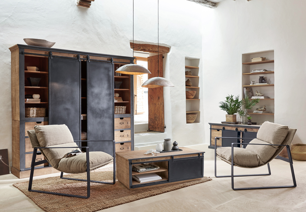 Salón industrial con muebles de madera y metal en tonos naturales, sillones cómodos con cojines beige y alfombra de yute