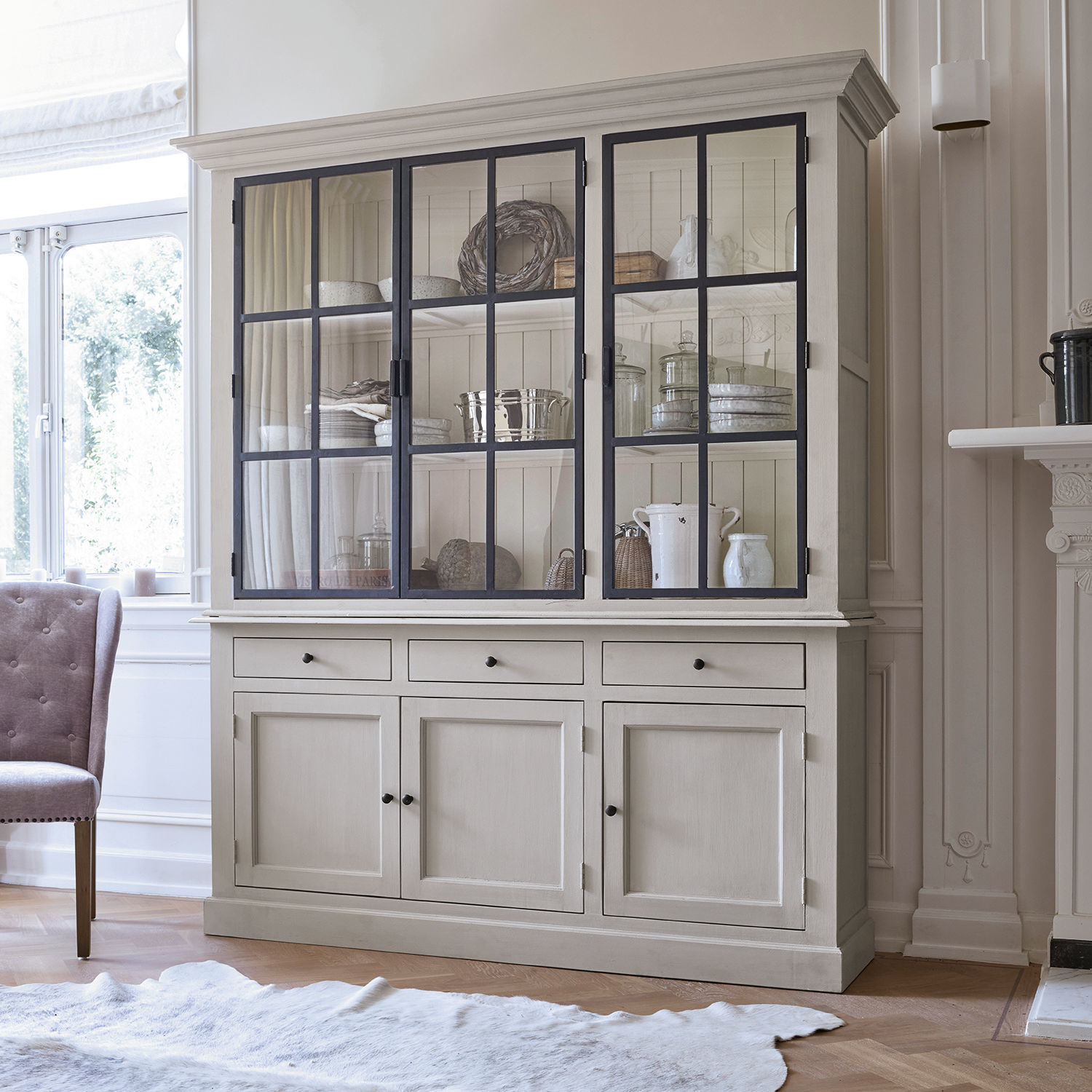 Armario Thilot Gran vitrina de madera beige con puertas de cristal y cajones para almacenamiento en salón luminoso