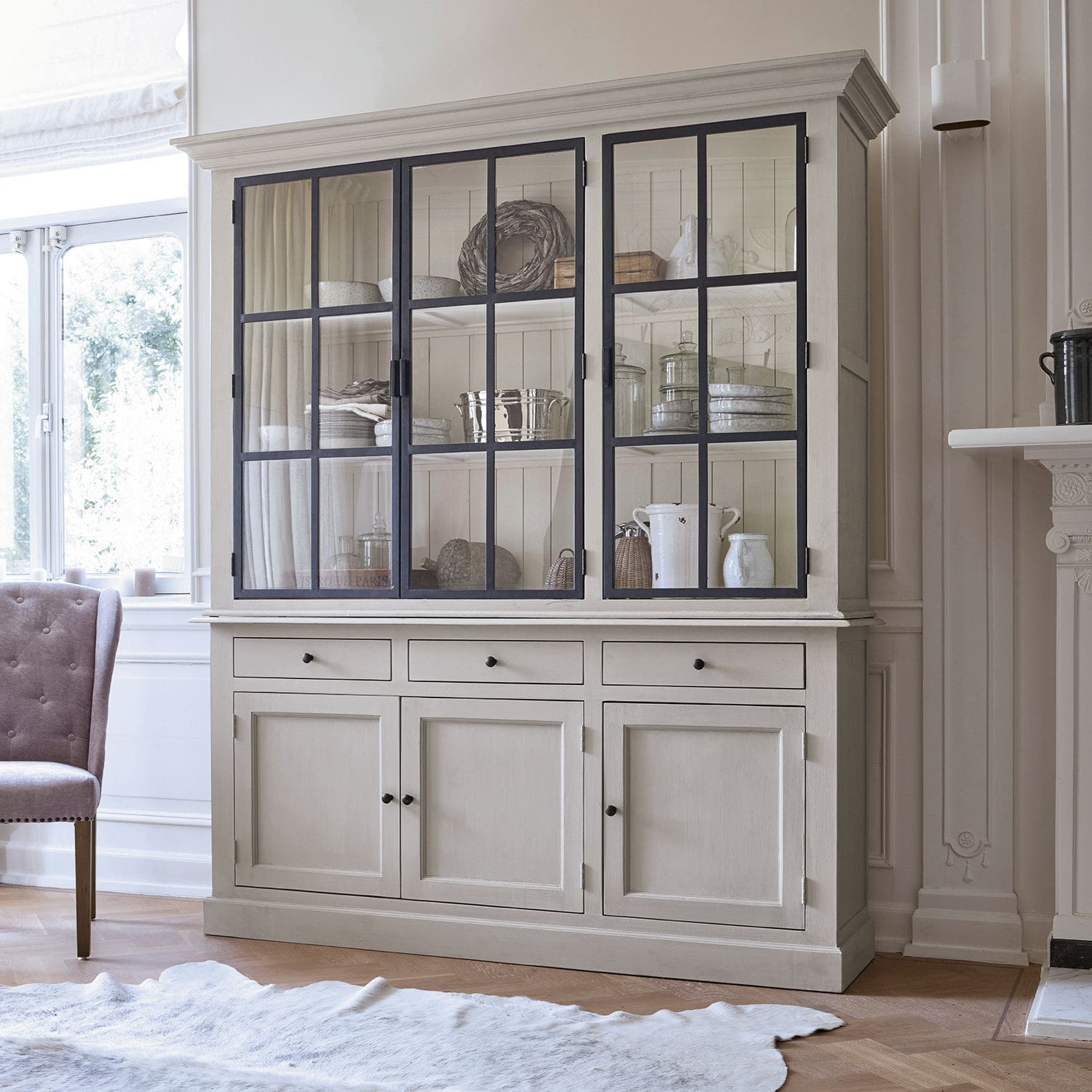 Vitrina Thilot Gran vitrina de madera beige con puertas de cristal y cajones para almacenamiento en salón luminoso