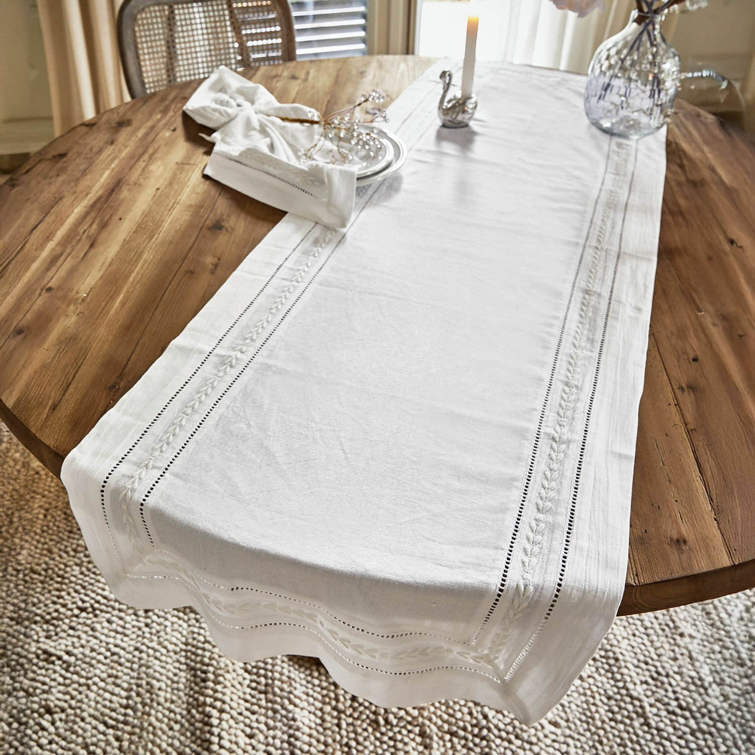 Camino de mesa Ellingford Camino de mesa blanco de lino con bordado delicado sobre mesa de madera, decoración y vela
