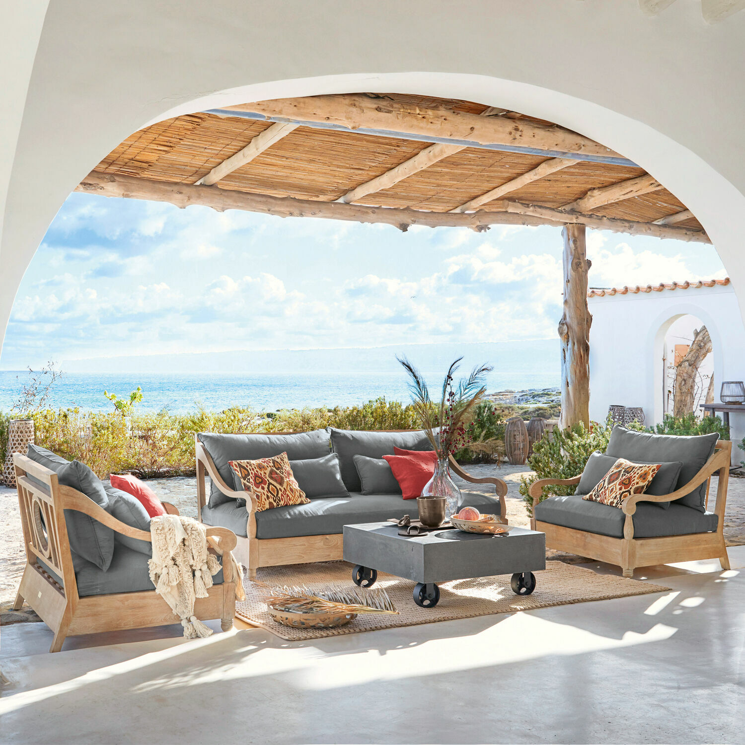 Grupo de asientos Montcassin Conjunto de muebles de jardín de madera con cojines grises en terraza con vista al mar
