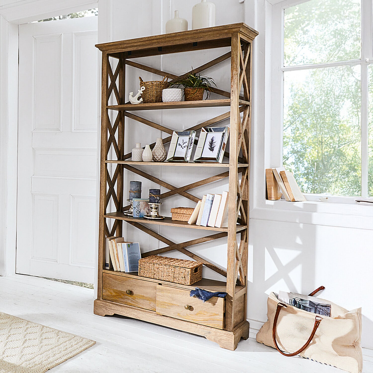 Estante Vélu Estantería de madera natural con cajones, decoraciones y libros en habitación luminosa
