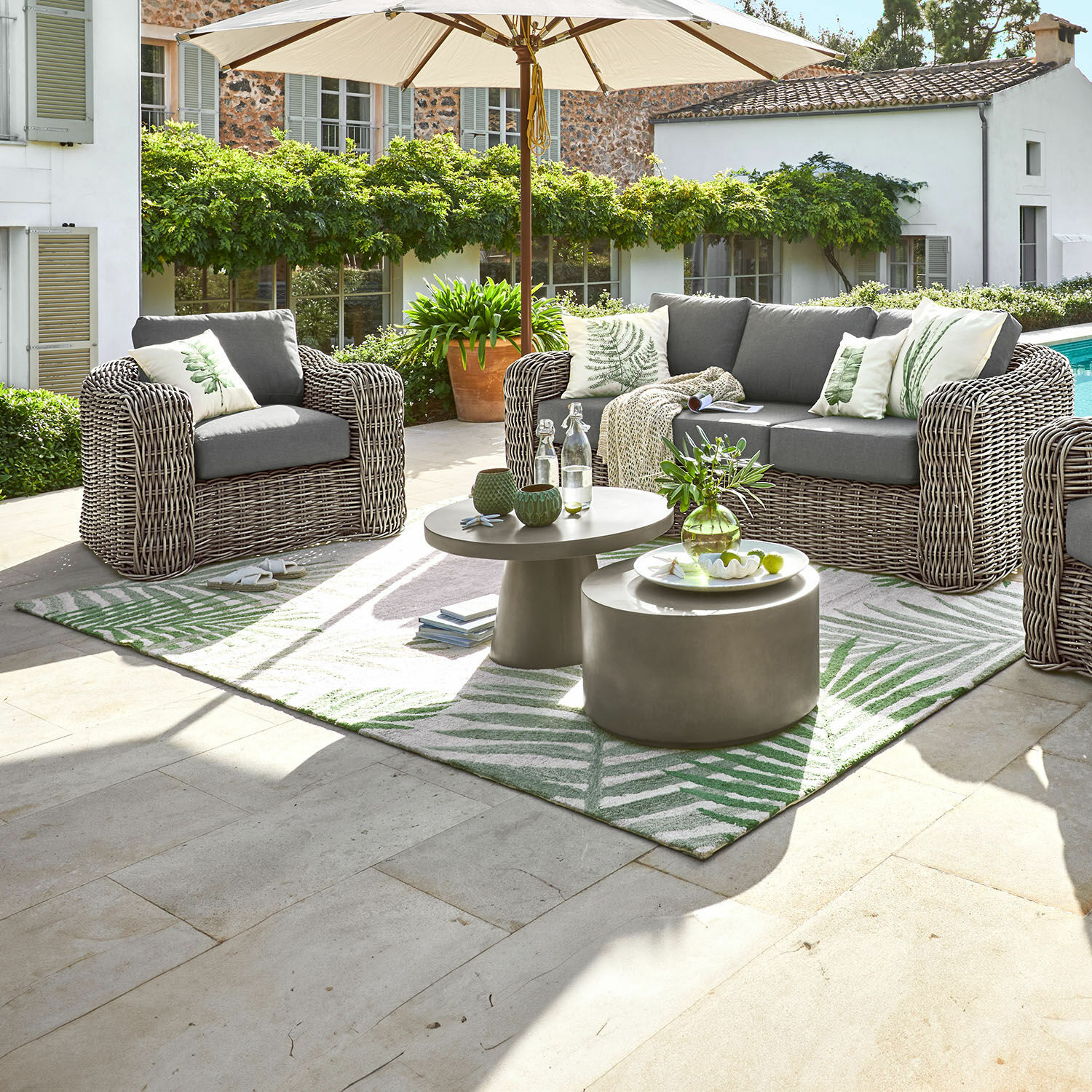 Alfombra para interiores y exteriores Marly Conjunto de muebles de jardín de tecnoratán gris con cojines y sombrilla en terraza soleada