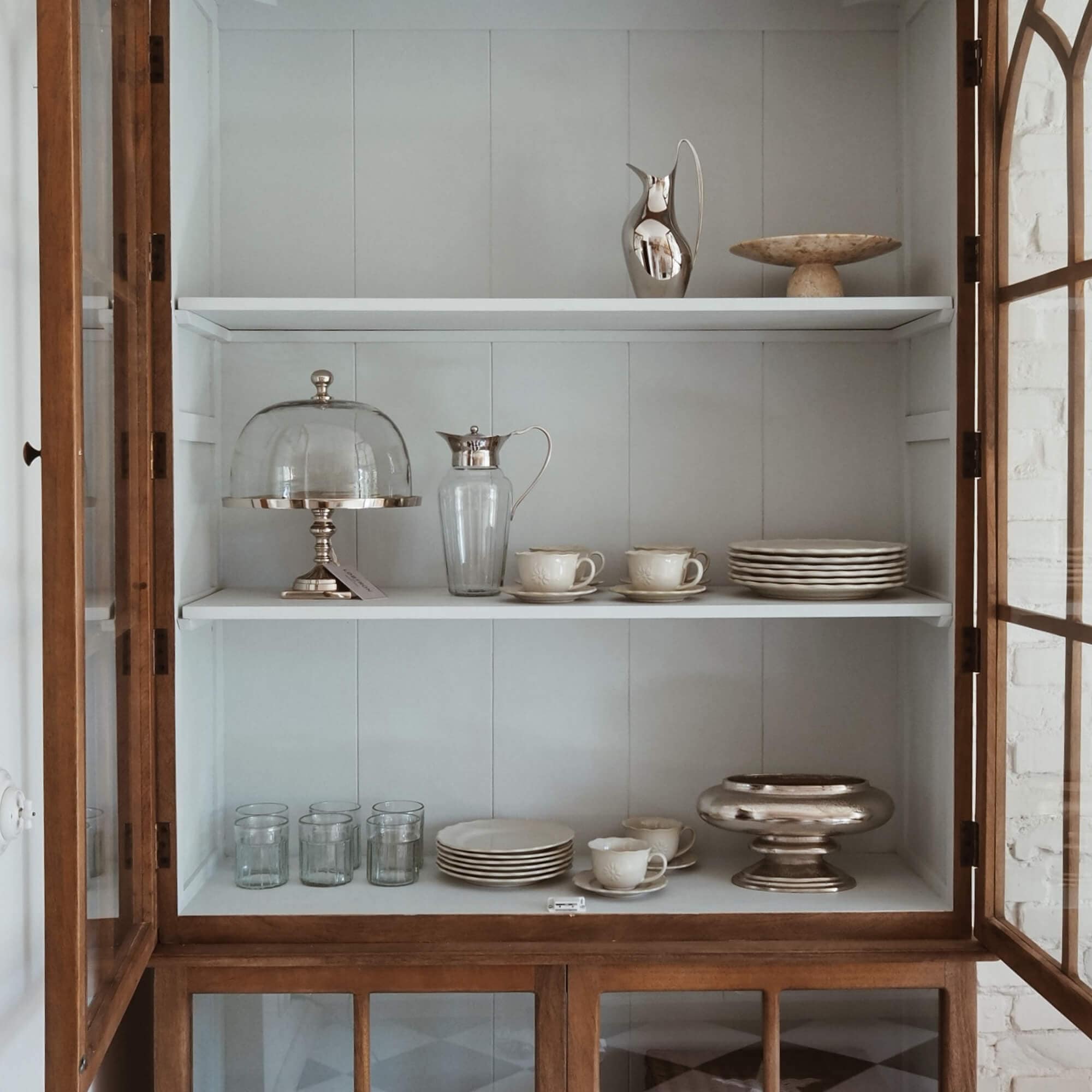 Vitrina de madera con estantes blancos, vajilla de porcelana y vasos de cristal para el hogar