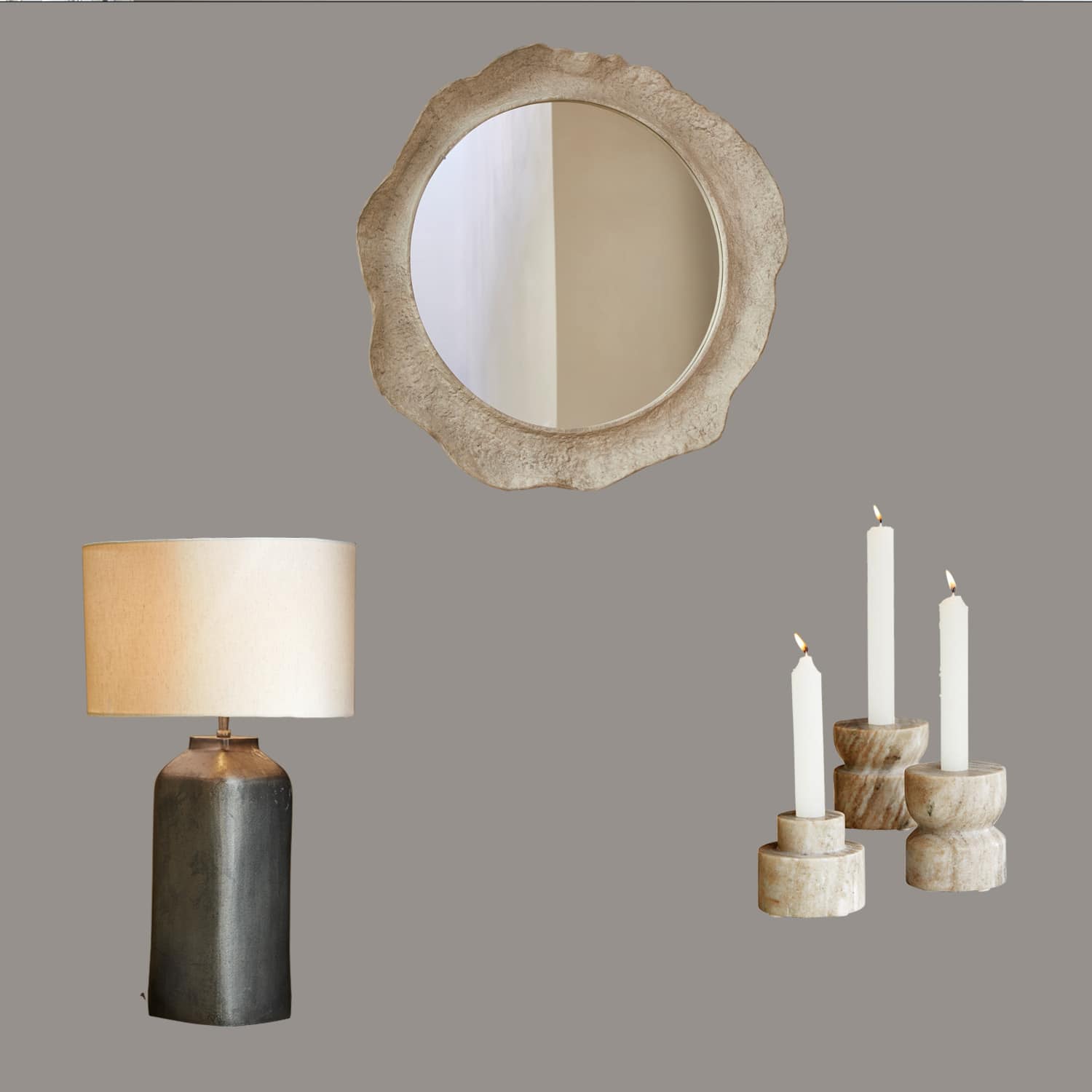 Lámpara de mesa con base de cerámica negra y pantalla beige, espejo redondo con marco de piedra y conjunto de candelabros