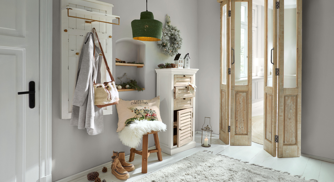 Interior acogedor con mueble de madera, lámpara verde y decoración navideña en tonos claros