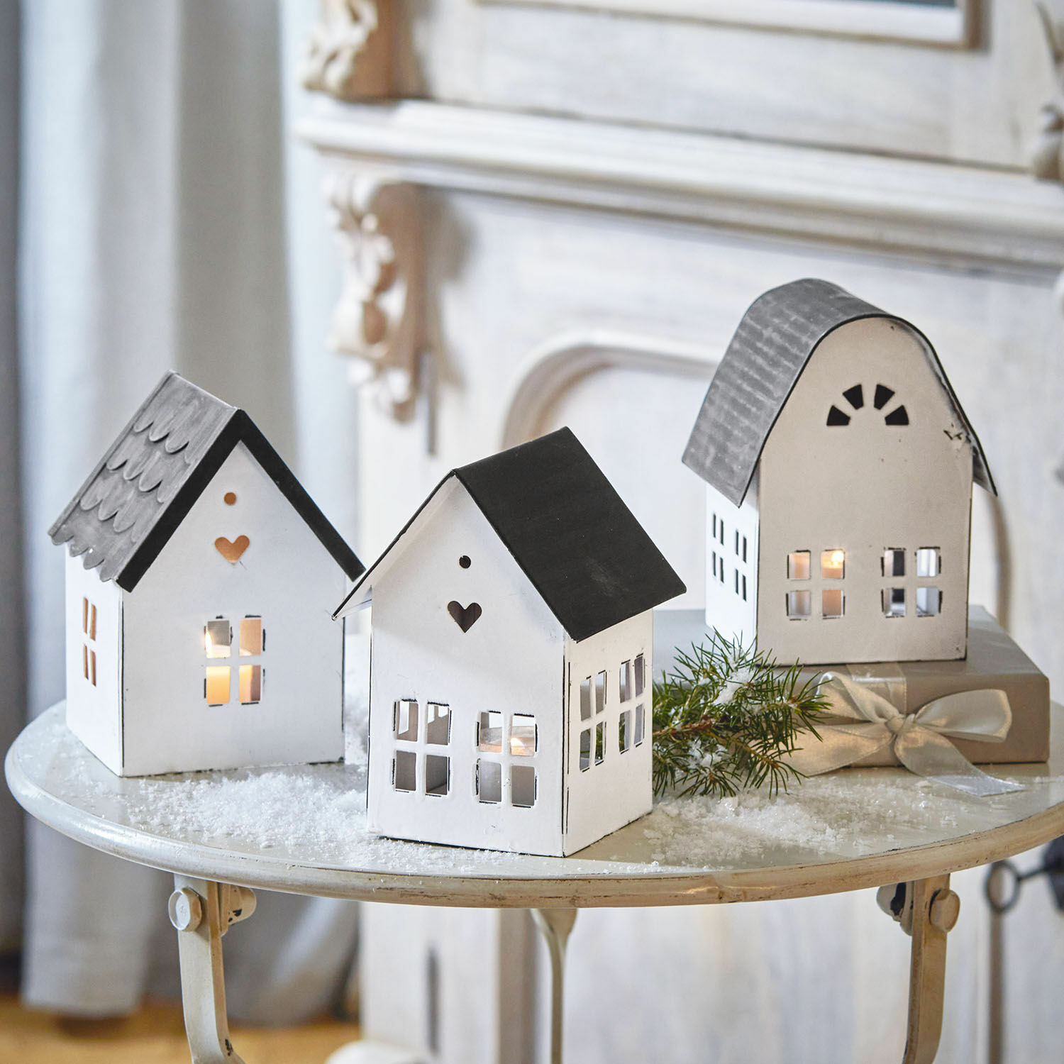 Set de 3 farolillos Lambray Faroles decorativos de metal en forma de casas blancas y negras sobre mesa festiva